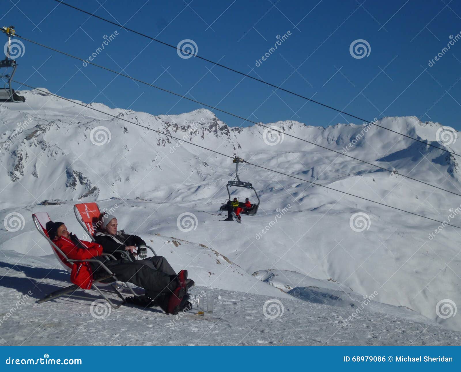 Détente dans les montagnes. Val D'Isere, France - 18 mars 2016 : Deux personnes détendent au soleil de montagne