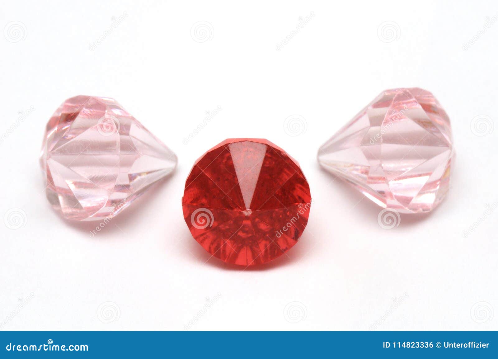 Three Ruby Red and Light Pink Colored Fake Diamonds Arkivfoto Bild av