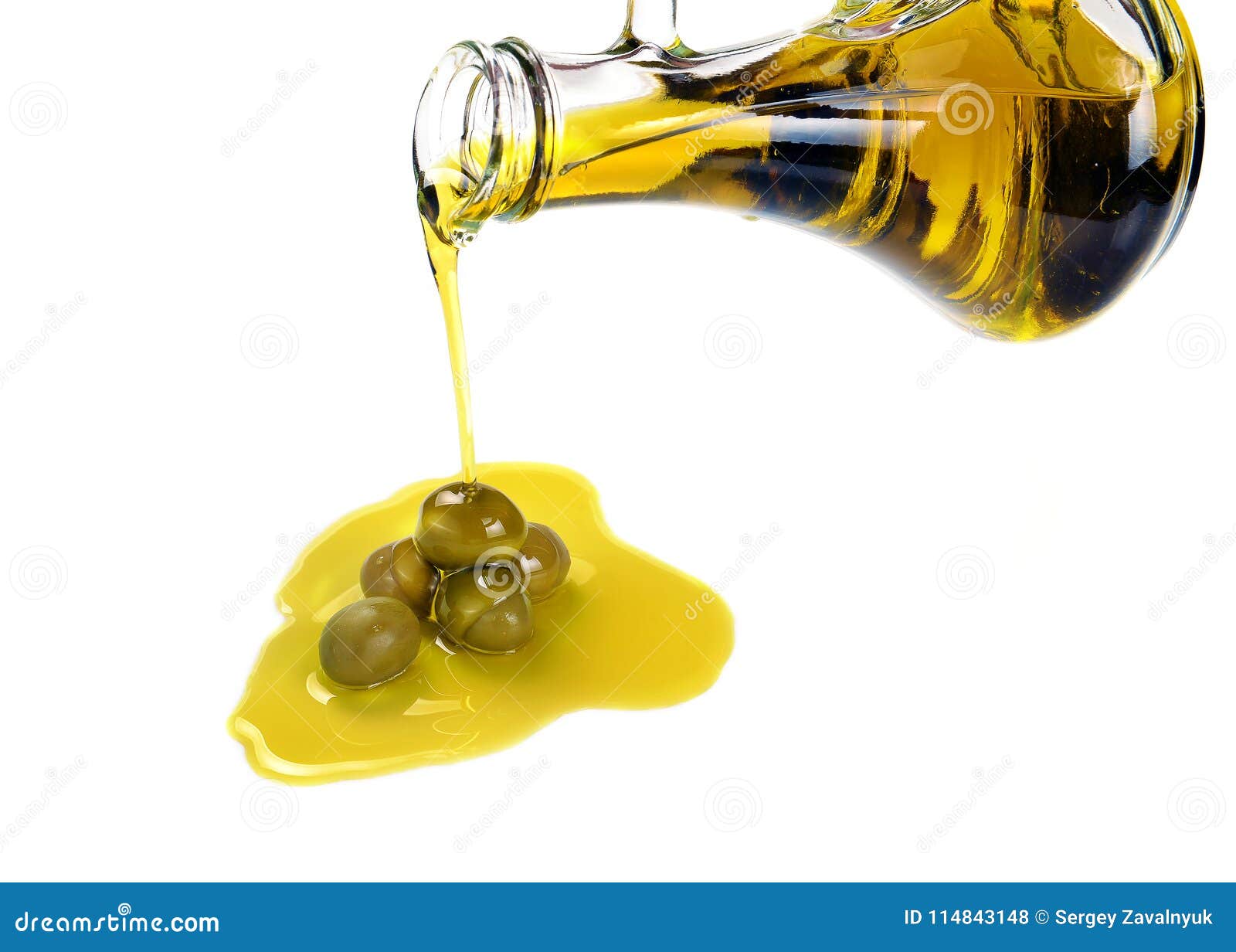 Pouring Olive Oil from a Bottle into a Green Olives Fotografia Stock