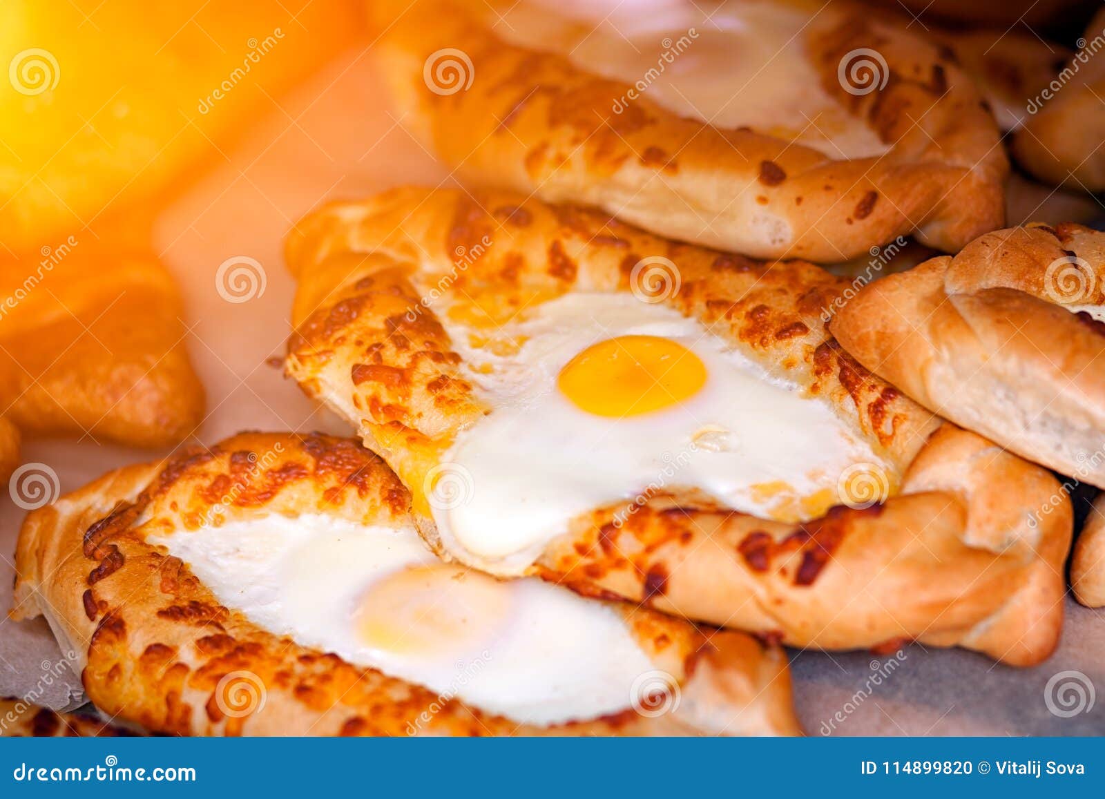 Khachapuri buns with egg. Close-up van verse heerlijke vers gebakken khachapuribroodjes met ei in rechte rijen