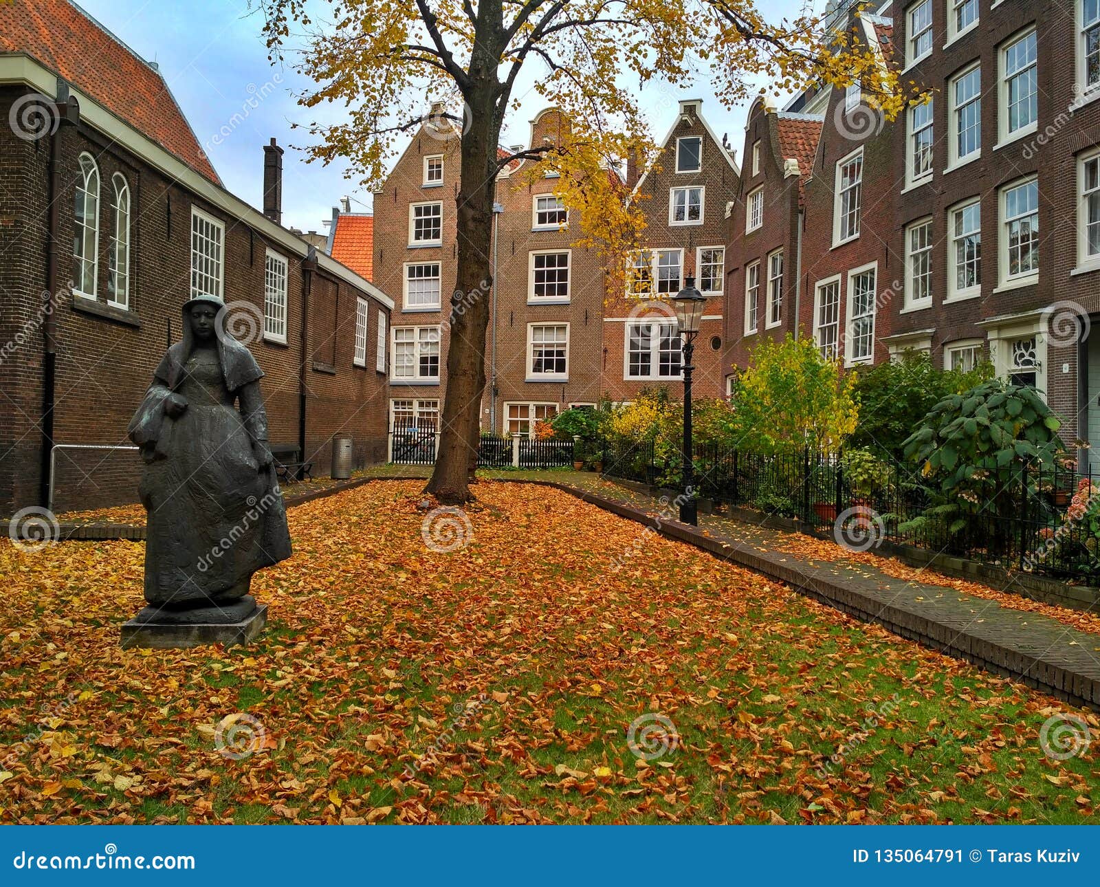 Amsterdam / The Netherlands - October 30 2016: Old yard Begijnhof with houses, garden and a sculpture. R r