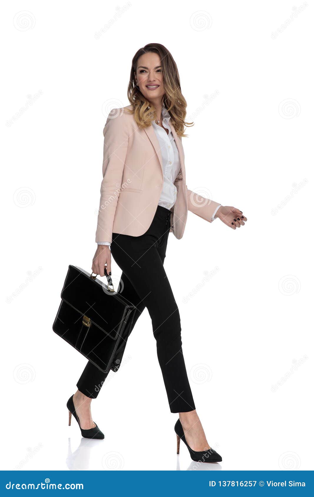 Businesswoman Holding Briefcase Walks and Looks To Side Immagine Stock