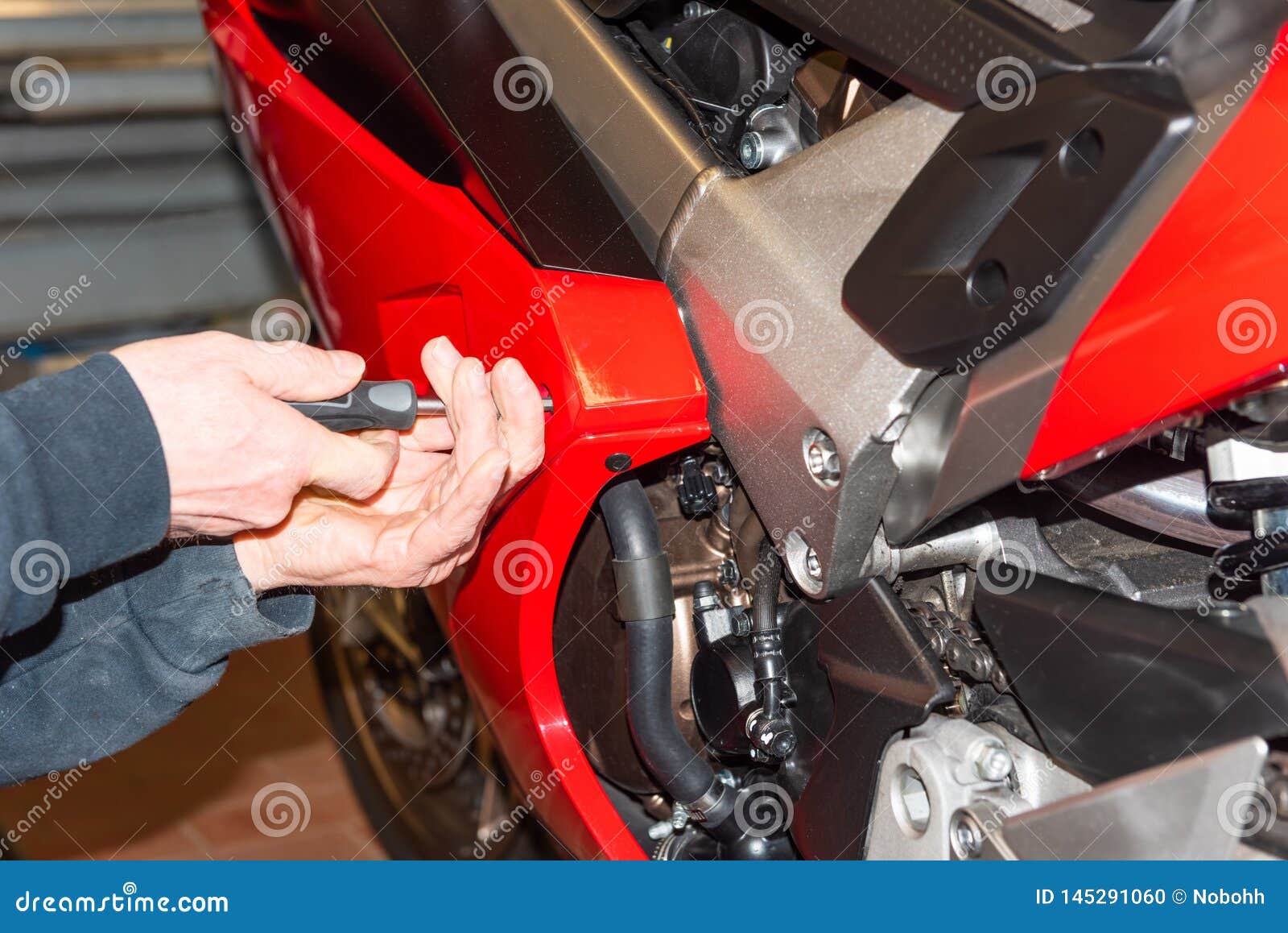 Motorcycle Mechanic Screwing on the Fairing of a Motorcycle Serie