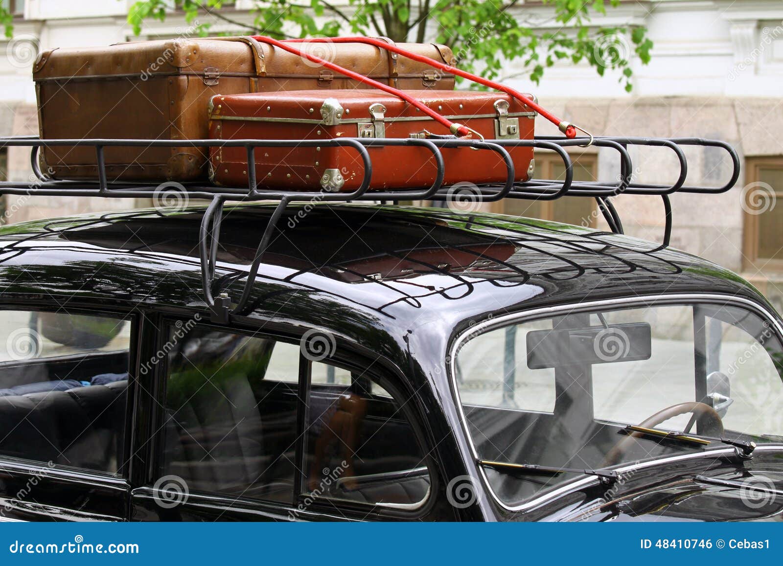 Vintage suitcases on the car roof. Vintage leather suitcases packed on top of the old car roof