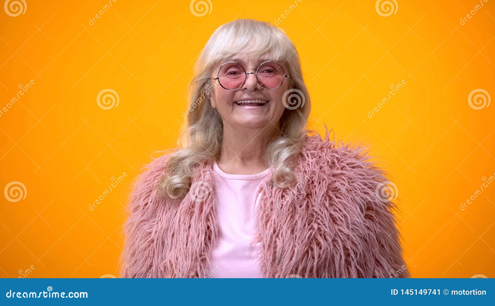 Cheerful Senior Woman in Pink Coat and Round Sunglasses Smiling on ...