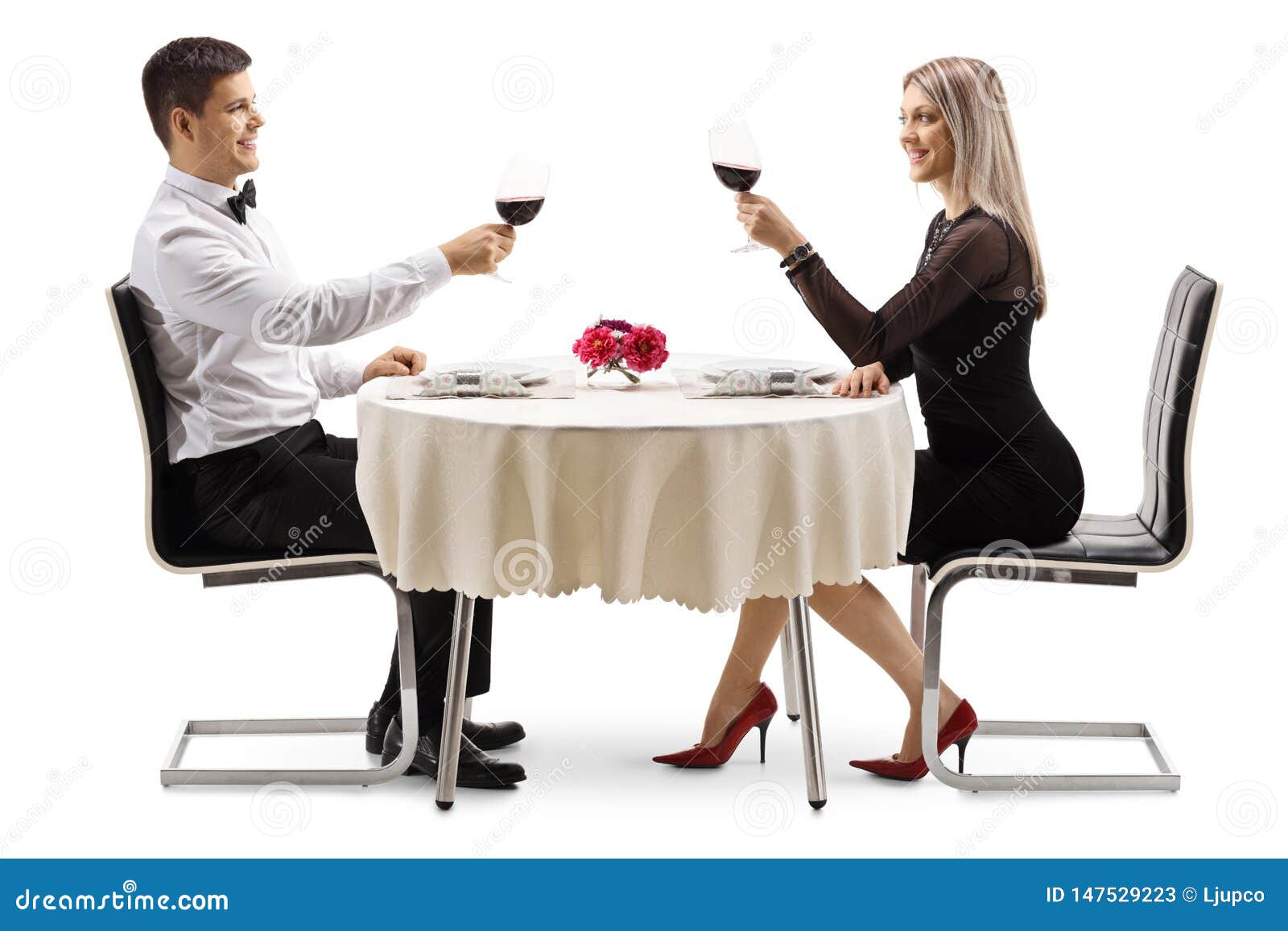 Young elegant couple toasting with wine at a table