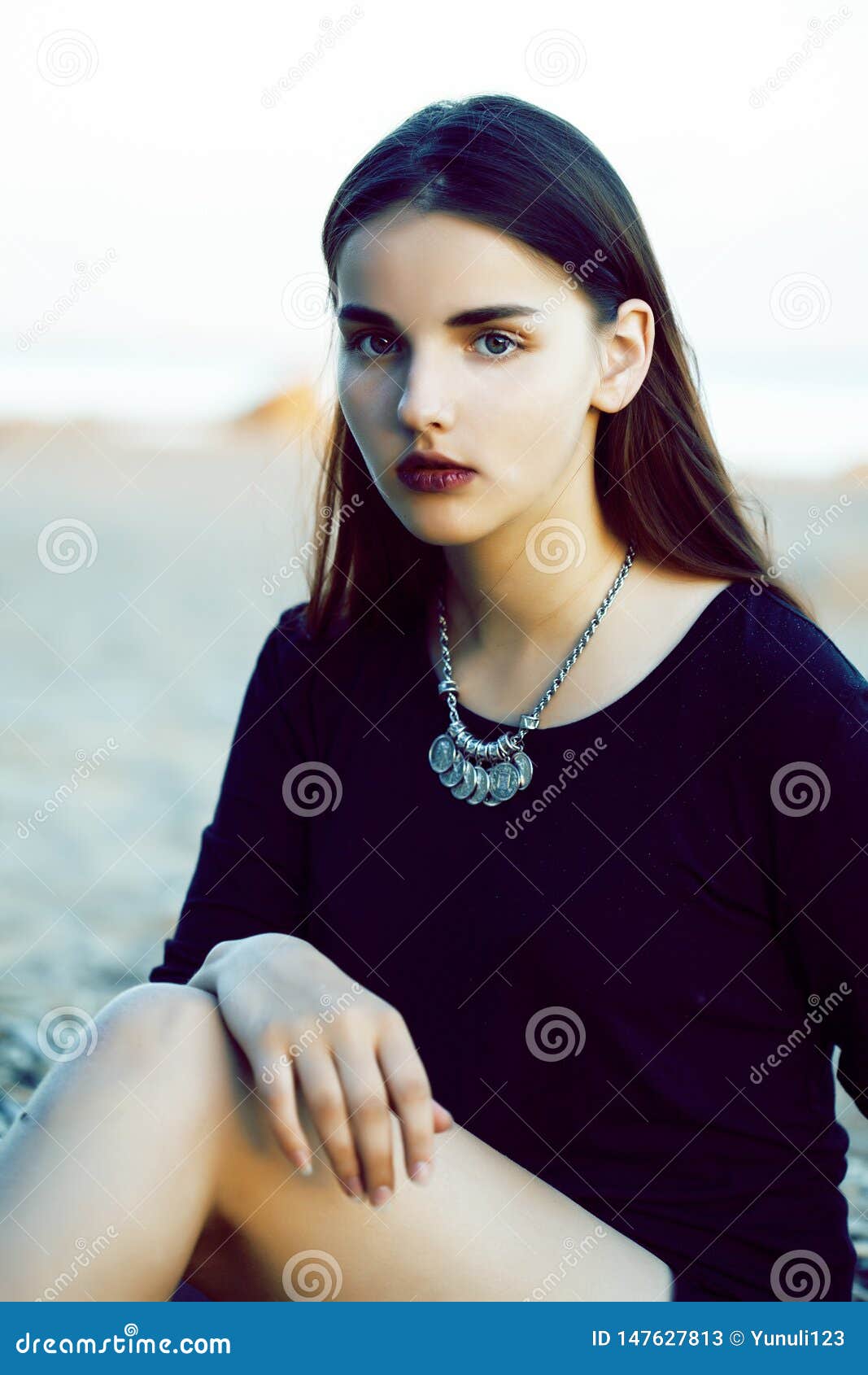 Young Pretty Brunette Girl With Long Hair Waiting Alone On Sand At