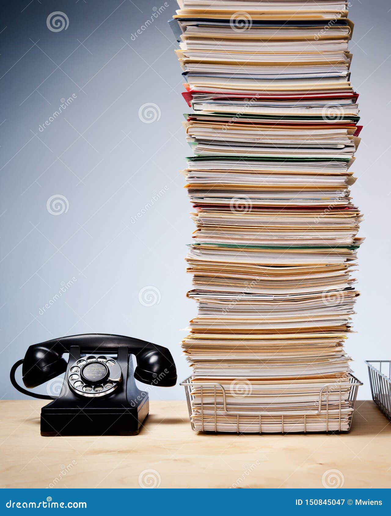 Pilha alta dos arquivos e do documento na mesa com telefone. Telefone velho na mesa com a pilha alta dos arquivos e do documento