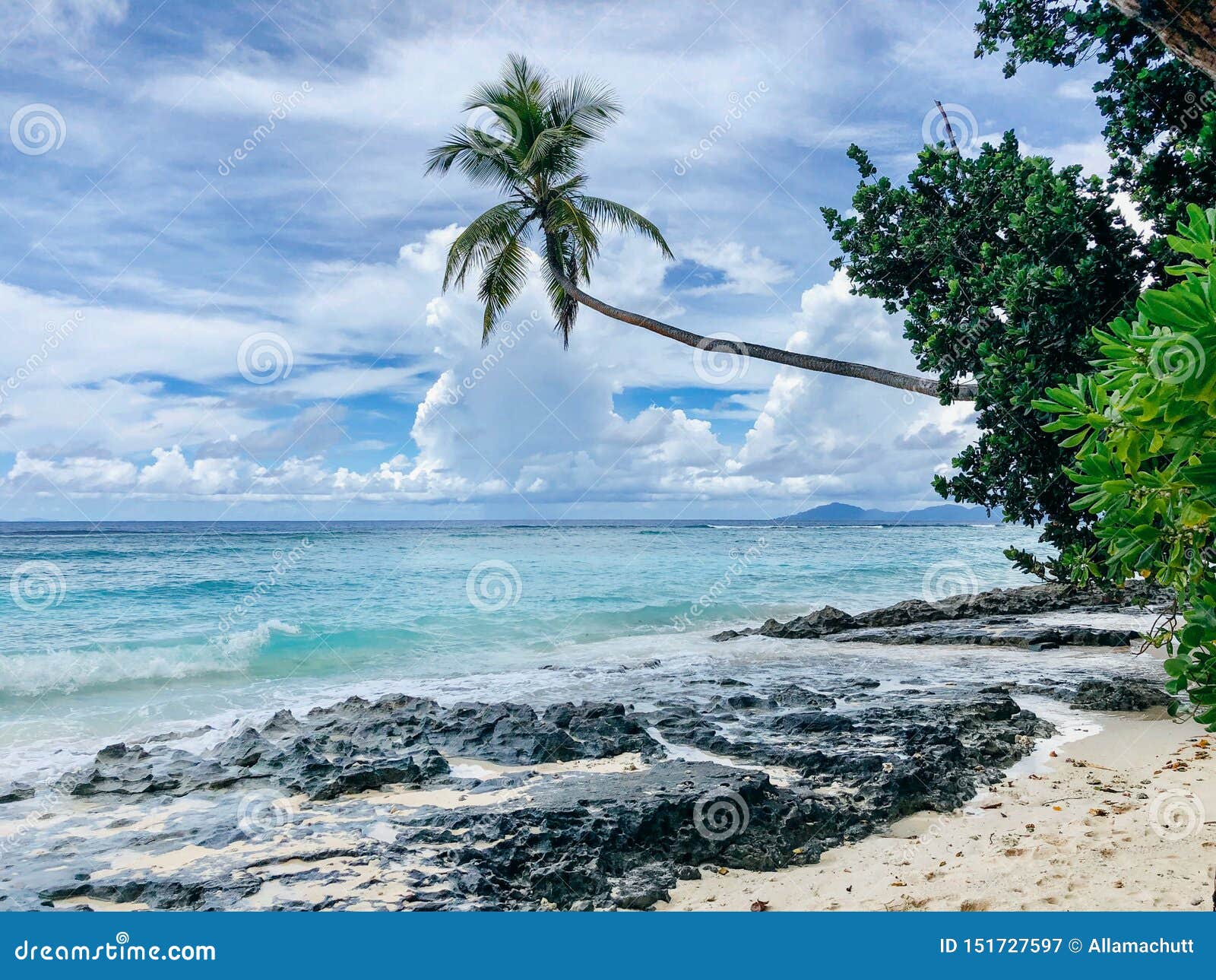 Seychelles Silhouette Island beach. Beautiful beach in Seychelles with rocks and palm trees, blue Indian Ocean and picturesque sky.