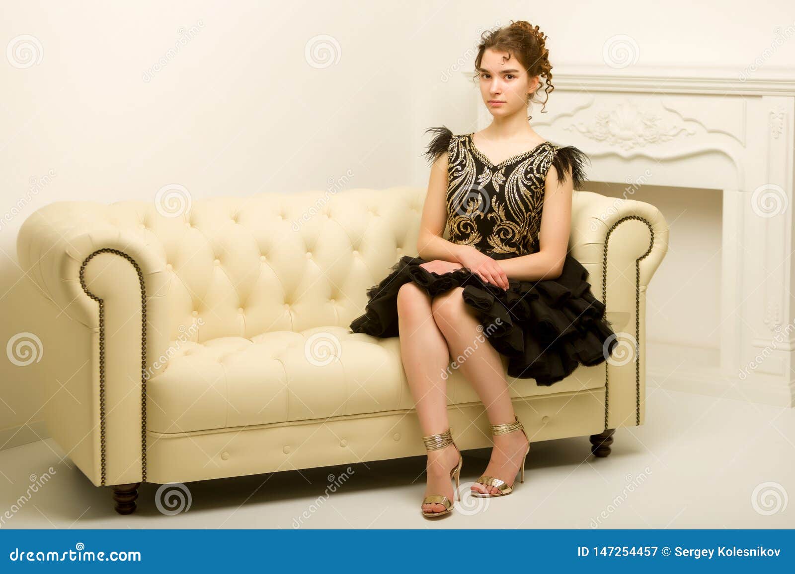 Teen Girl in Elegant Dress Sitting on the Couch. Imagen de archivo ...