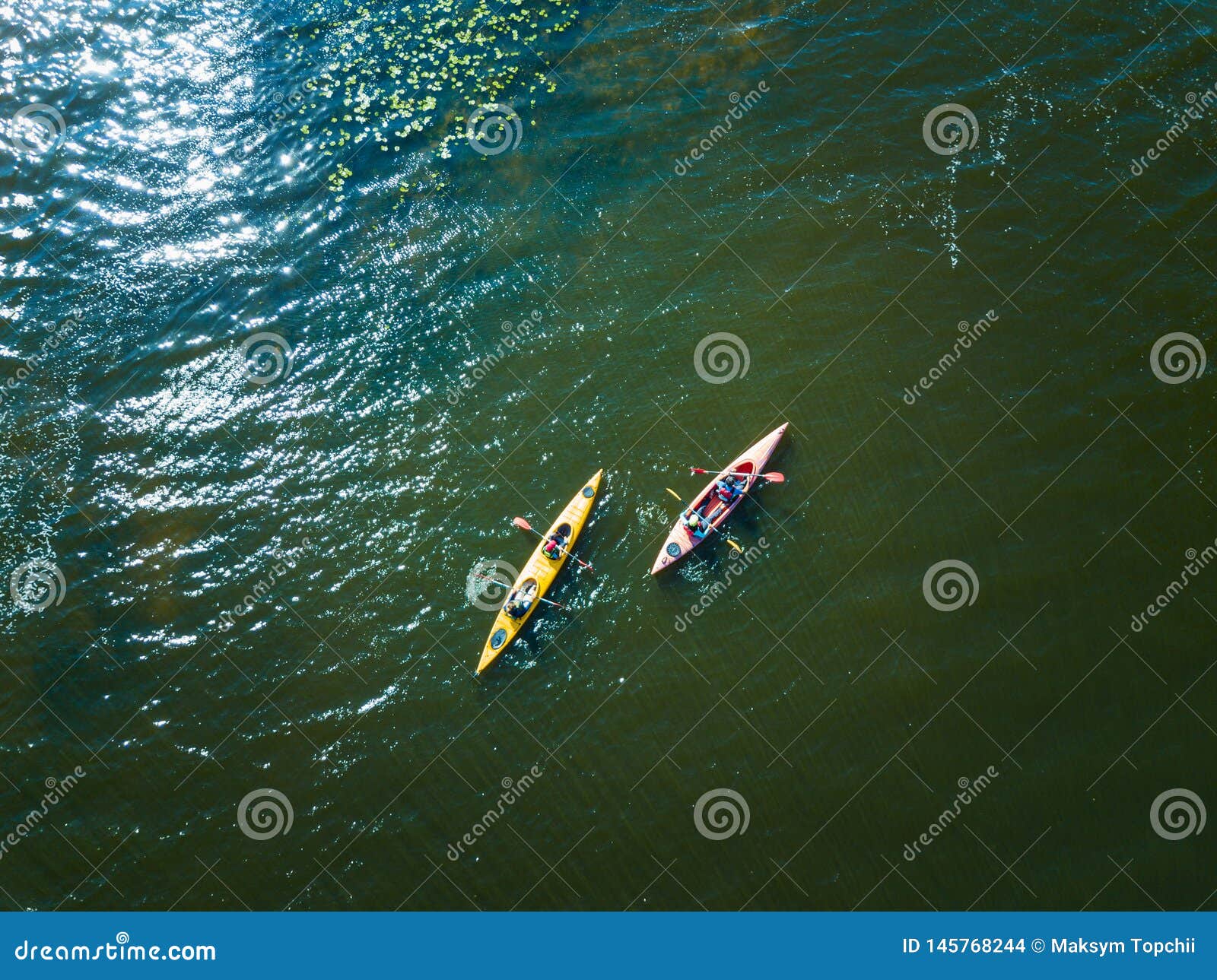 E r. Aerial drone bird`s eye view photo of Happy family with two kids enjoying kayak ride on beautiful river. Little boy and teenager girl with their parents kayaking on hot summer day. Water sport fun. Canoe and boat for children