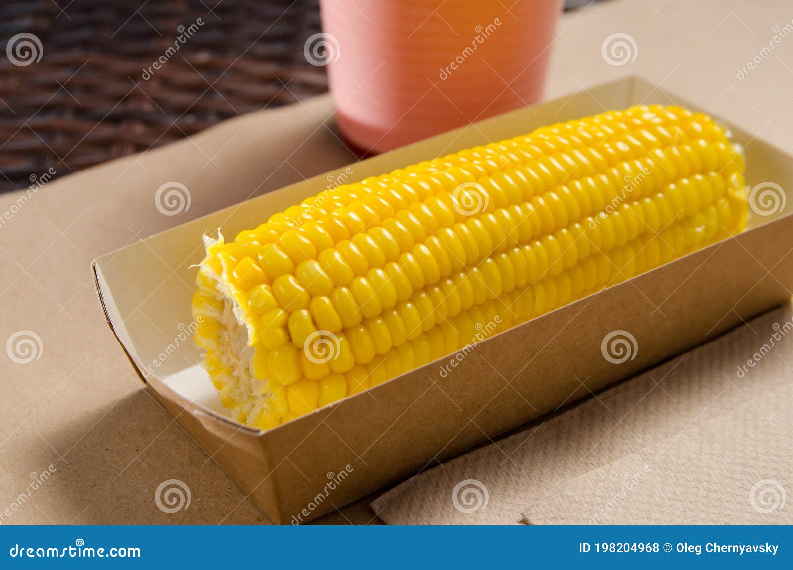 An Ear of Boiled Corn in an Ecofriendly Cardboard Box Next To a
