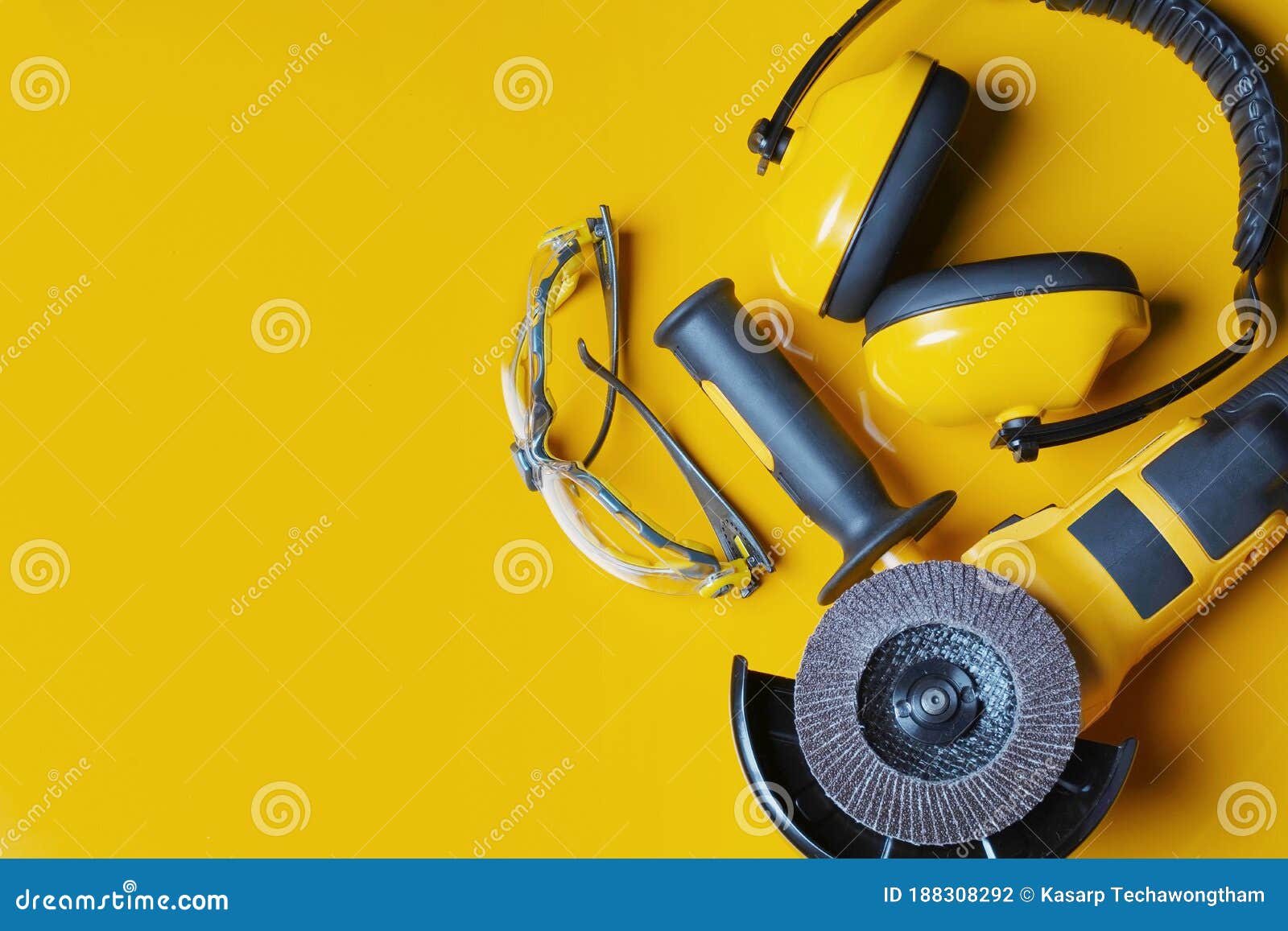 Ear Muffs, Angle Grinder and Safety Glasses on Yellow Background .Work