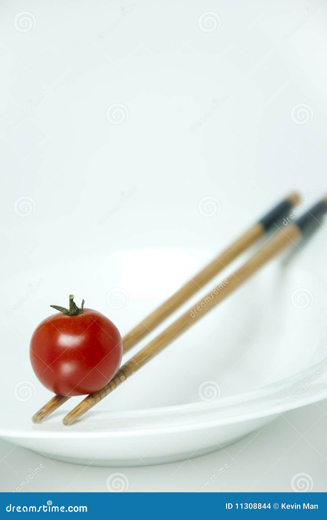 East meet west. A balance tomato on a chopstick