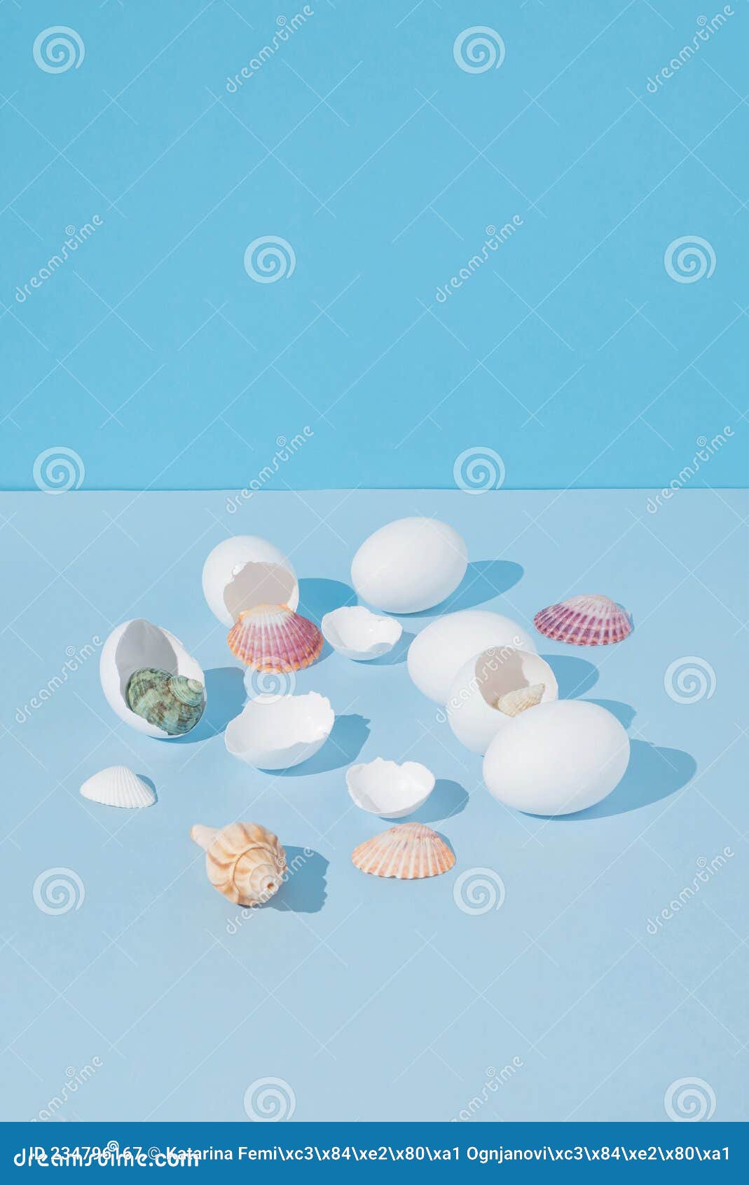 2021 easter creative still life composition with colorful sea shells coming out of cracked white eggs. modern, minimal background