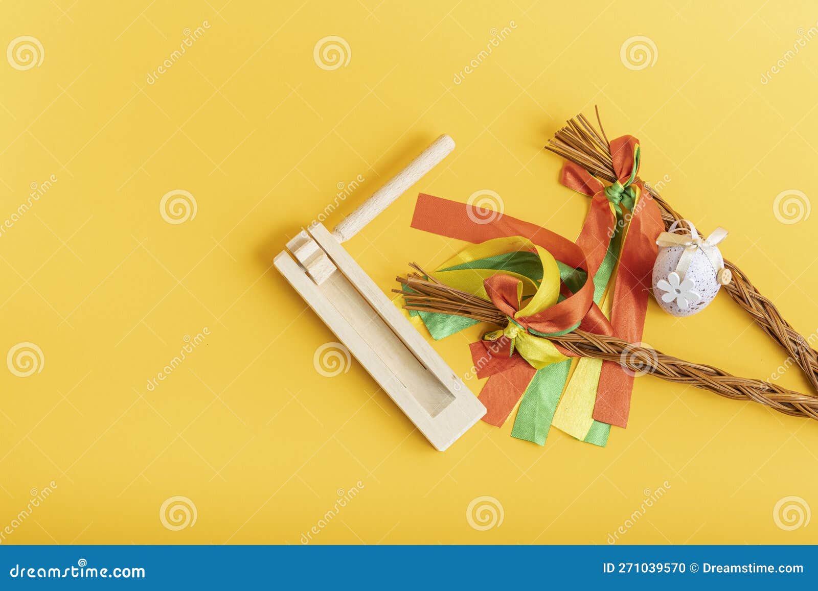 easter whips, egg and rattle clapper on orange background, flat lay, top view