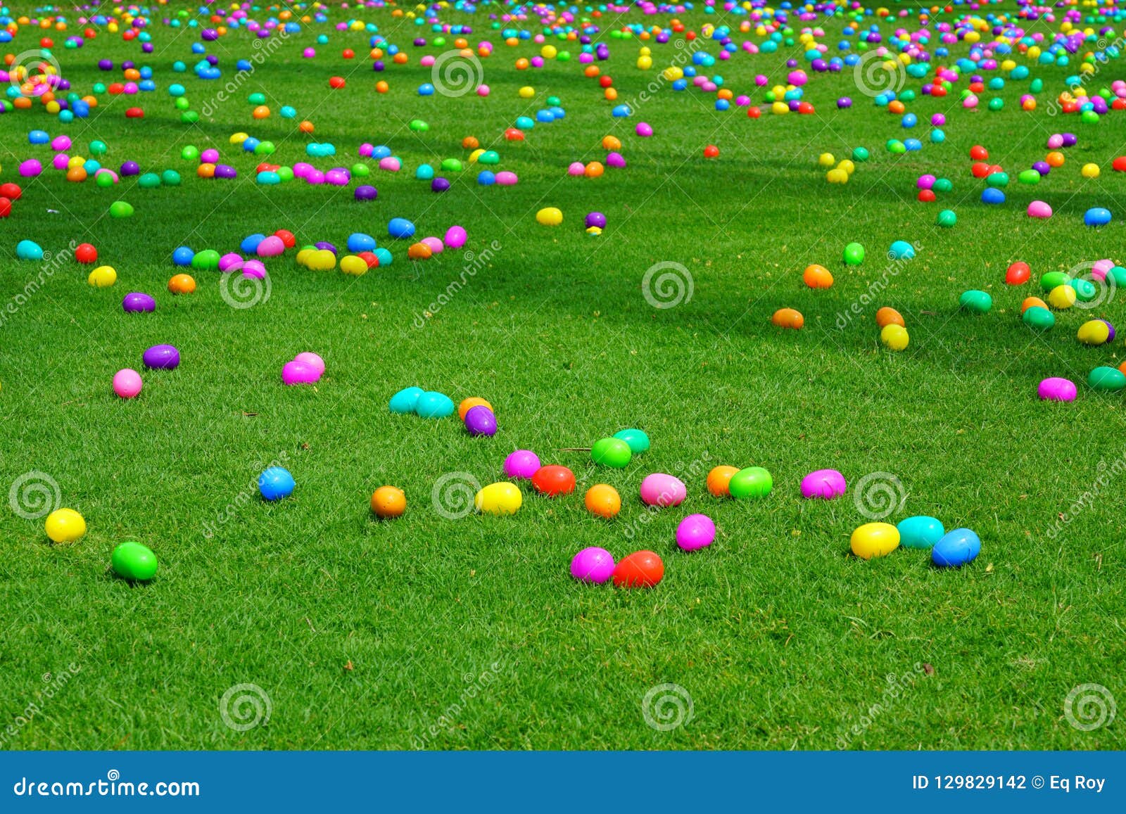 an easter egg hunt with plastic eggs on a green lawn