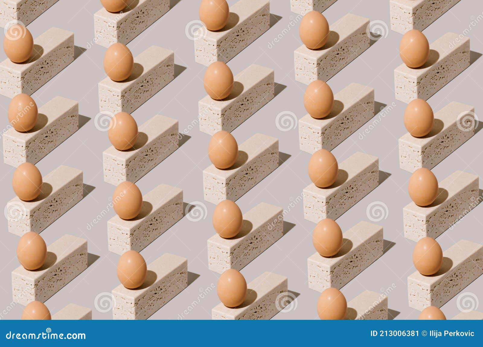 Easter egg pattern made of natural eggs on top of travertine marble blocks on a gray background. 2021 unique still life concept. Surreal vintage food composition
