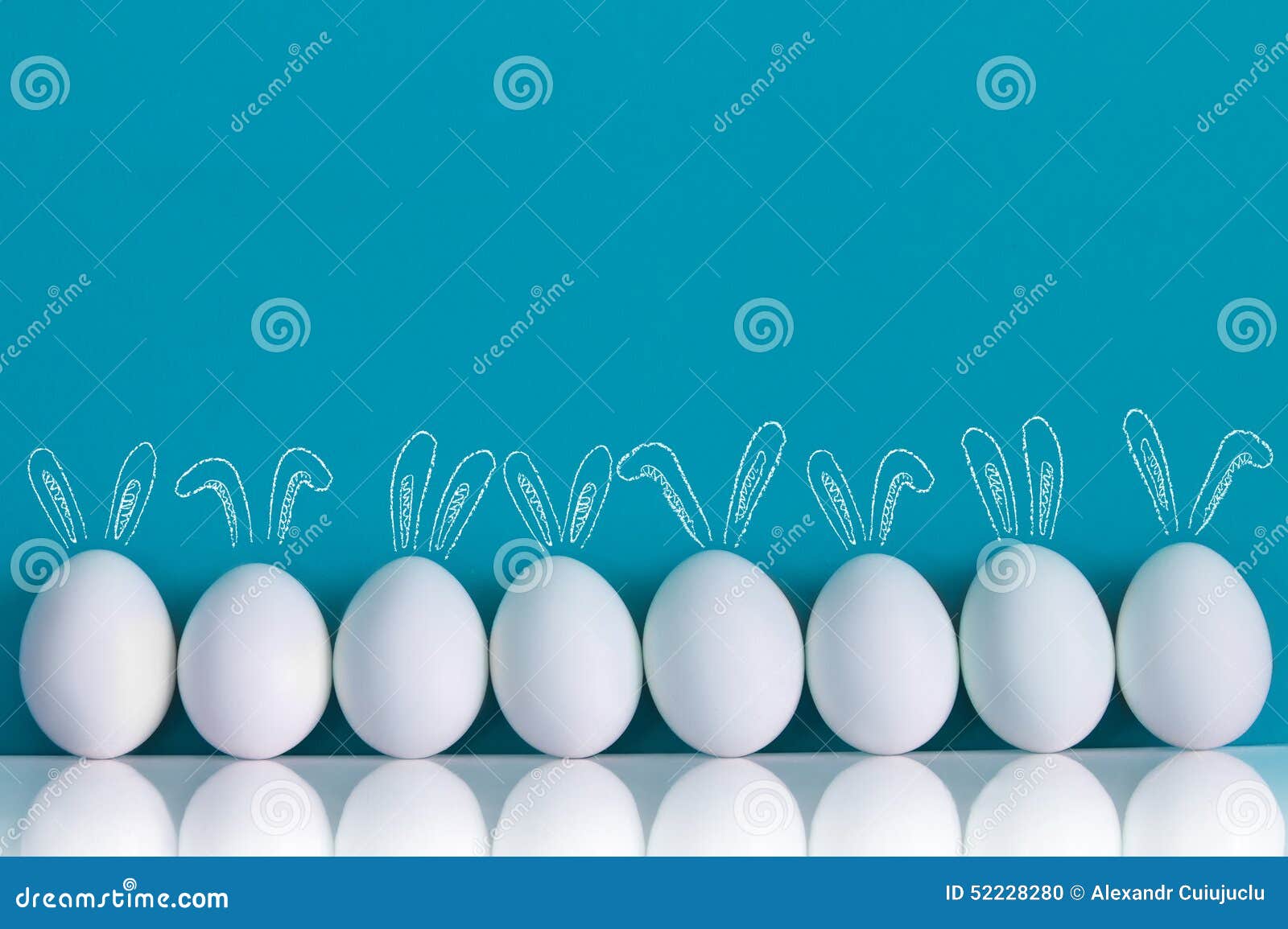 easter eggs painted with rabbits ears and ballooons on the blue background