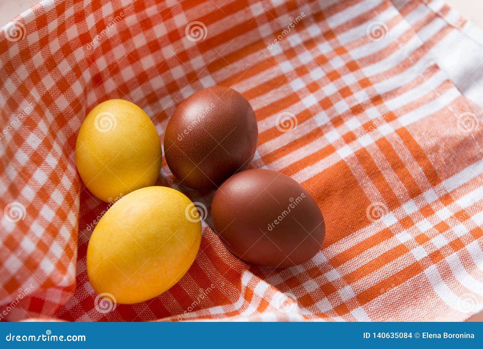 4 easter eggs, yellow and brown boiled eggs on an orange towel