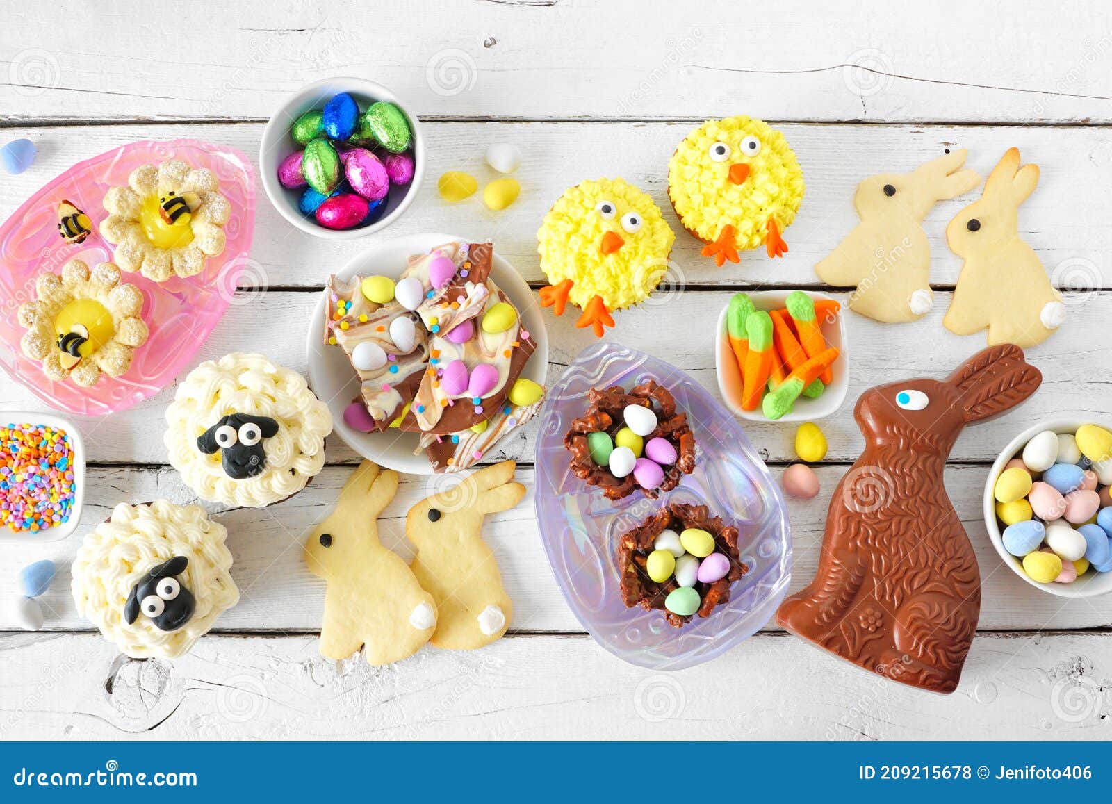 easter table scene with assorted desserts and sweets over a white wood background