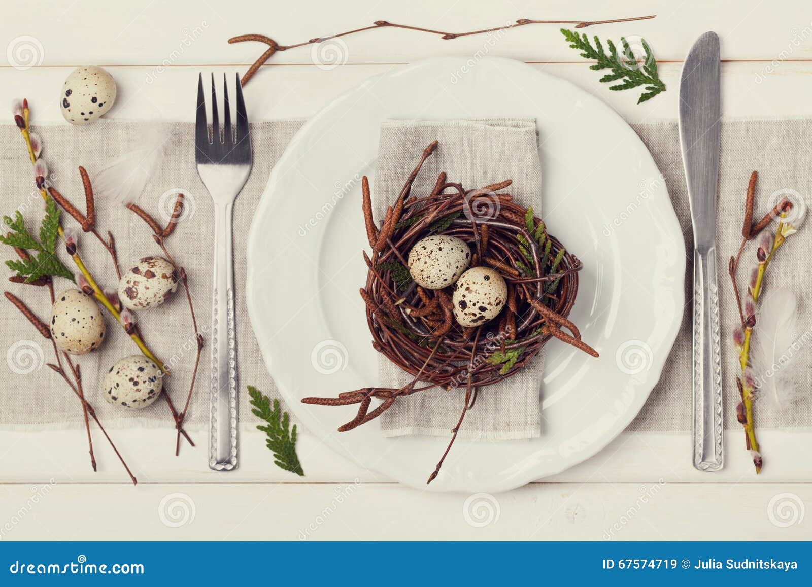 easter table setting with eggs and spring decoration on rustic background, vintage toning