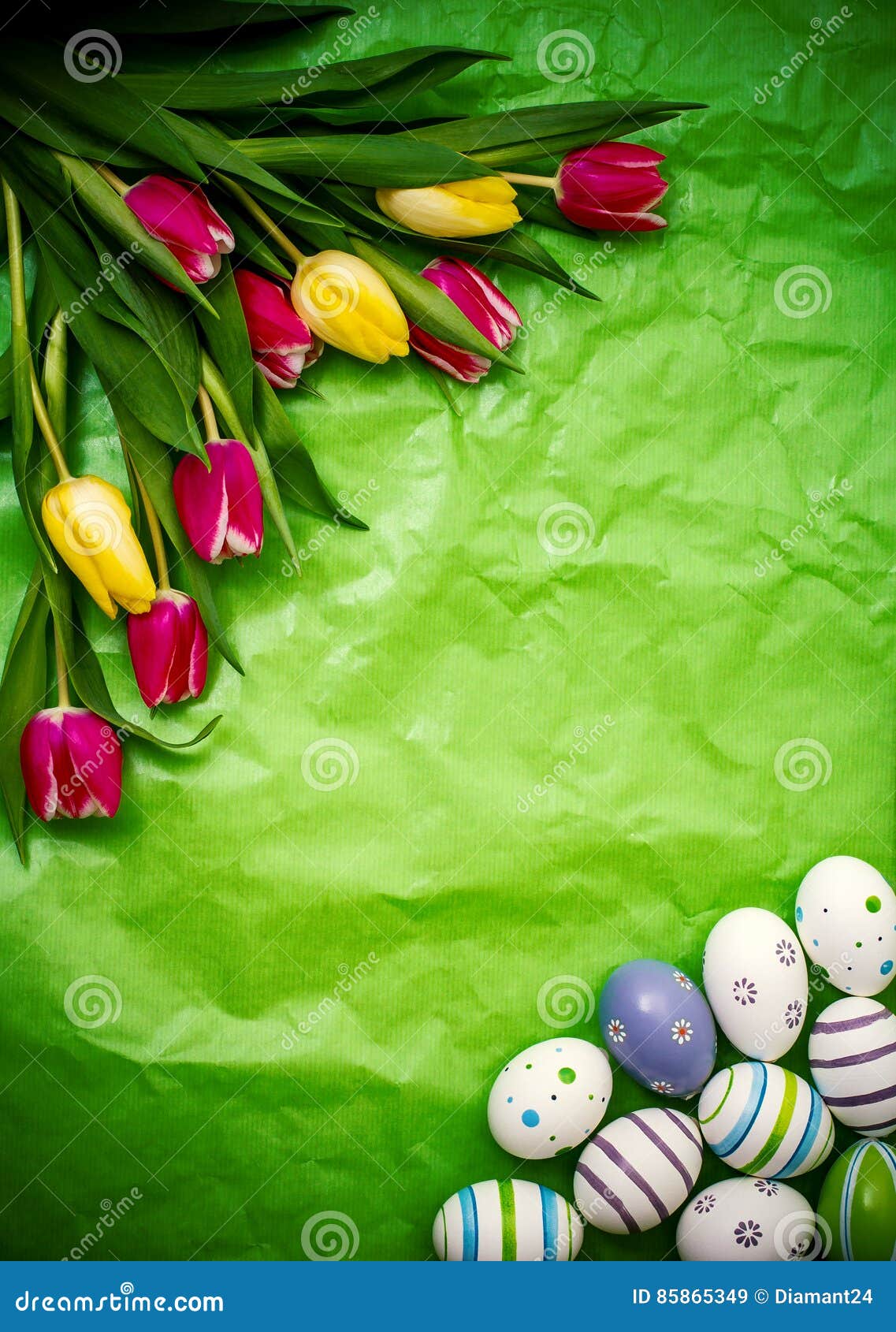 Eastern egg, tulips on green crumpled wrapping paper, top view