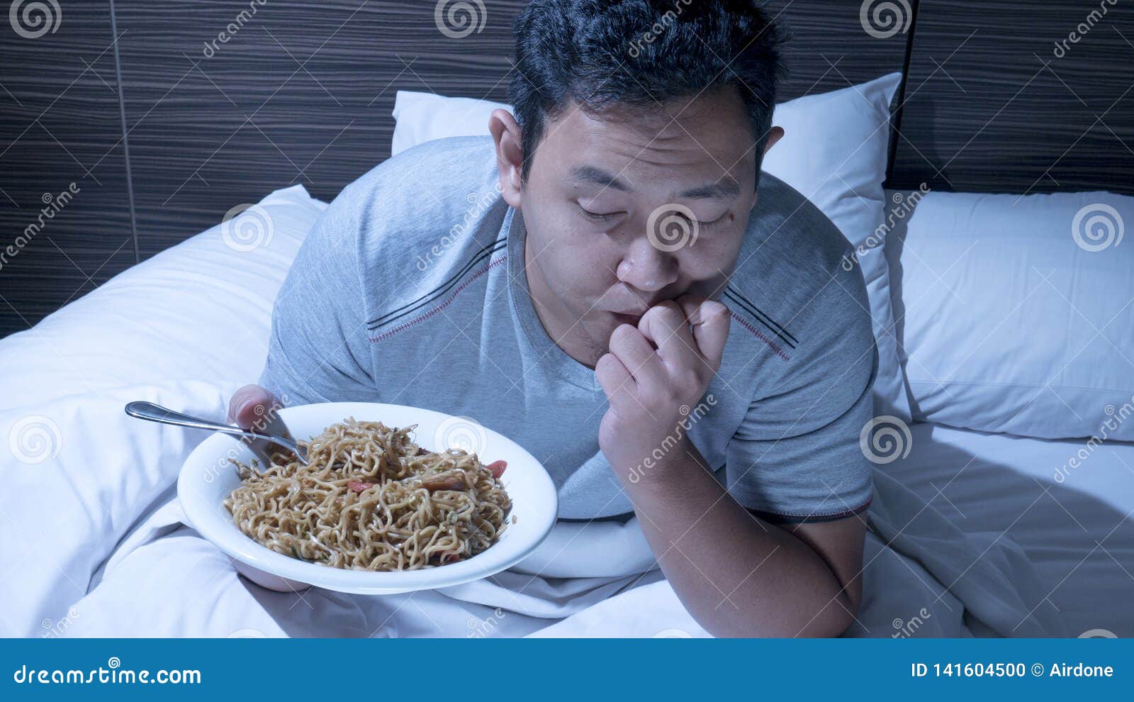 Eat At Midnight, Bad Eating Habit, Late Night Dinner On Bed Stock Photo