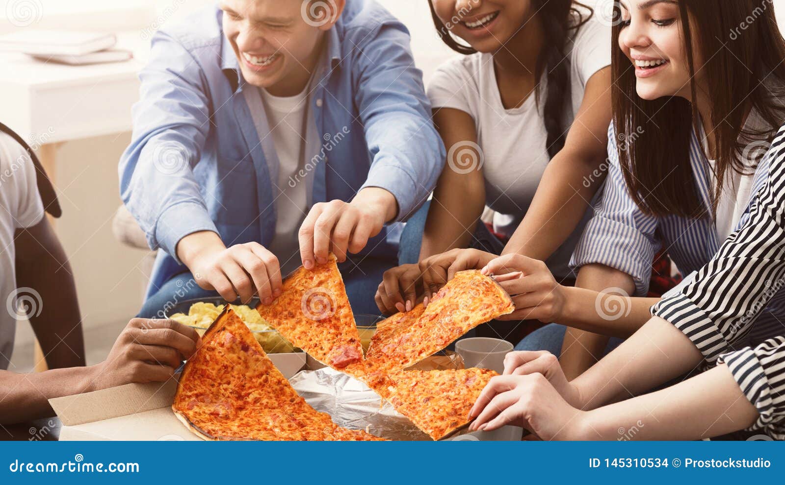 Happy african american friends eating pizza at home Stock Photo by  Prostock-studio