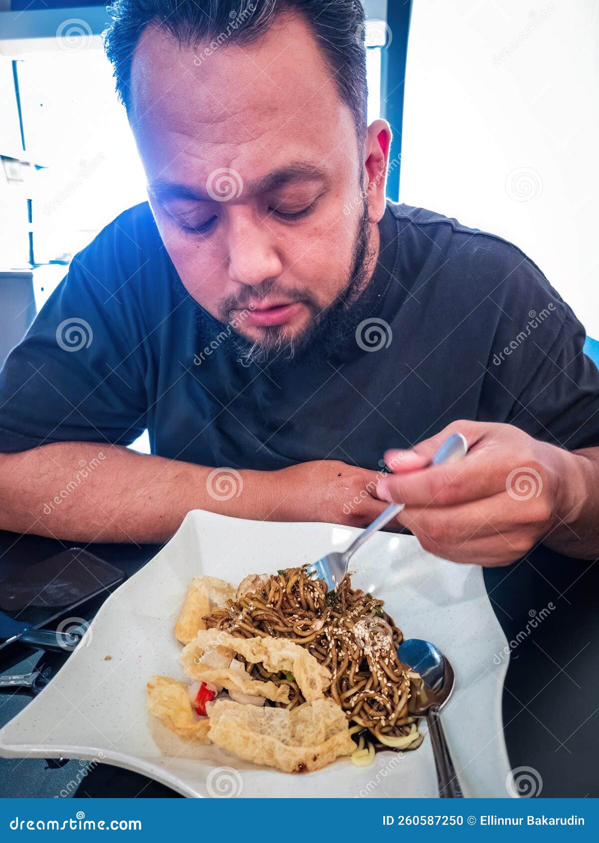 eating the wantan noodle with fried bean curd and sesame