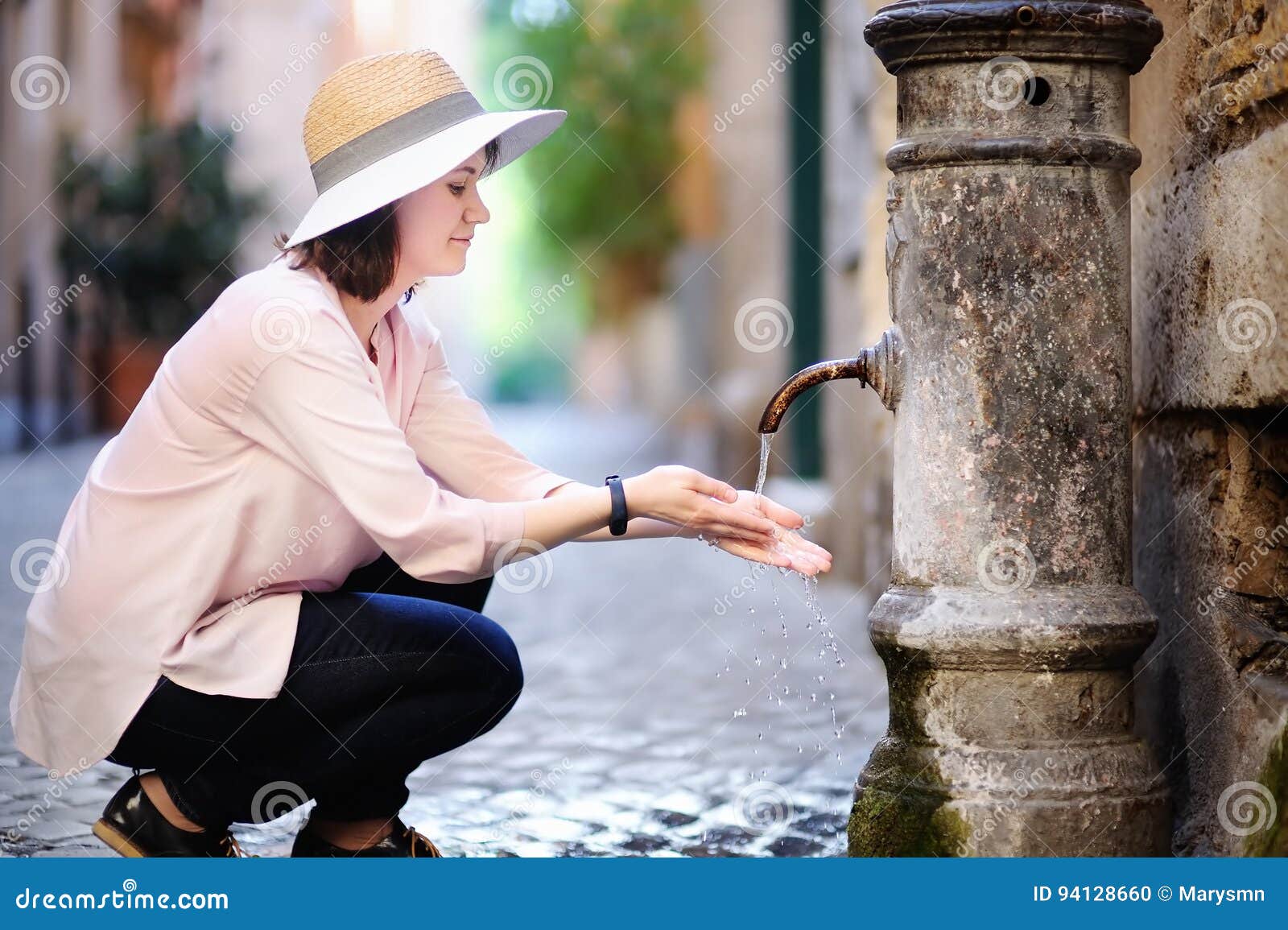 Mains de lavage de jeune femme dans une fontaine de ville Eau propre potable de jeune femme de la fontaine à Rome, Italie