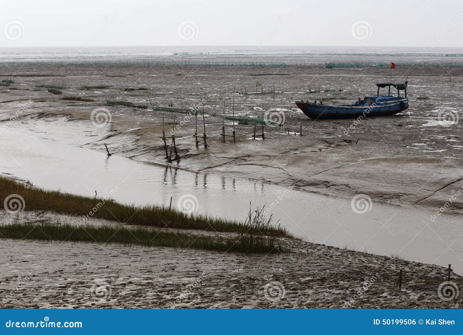 after the ebb, the boat ran aground on the tidal flat river of mud,