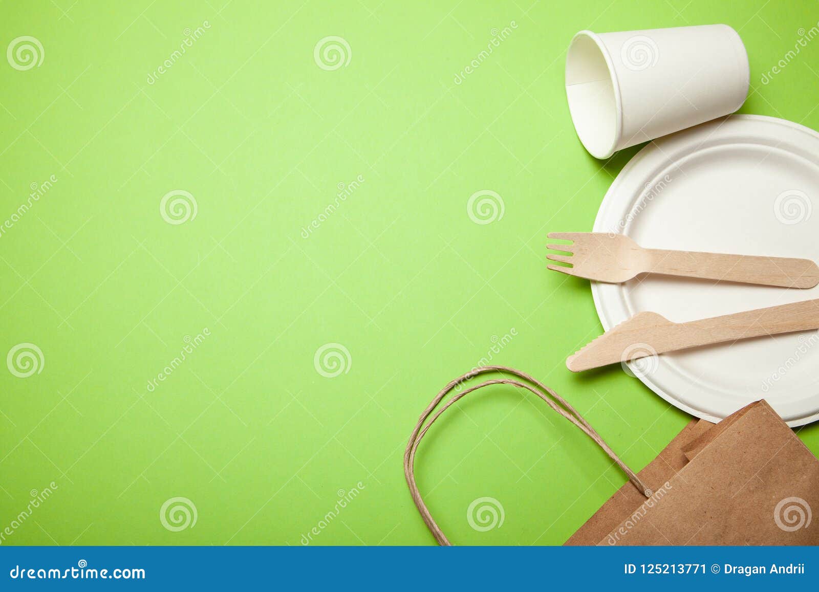 Ecofriendly Disposable Utensils Made of Bamboo Wood and Paper on Green