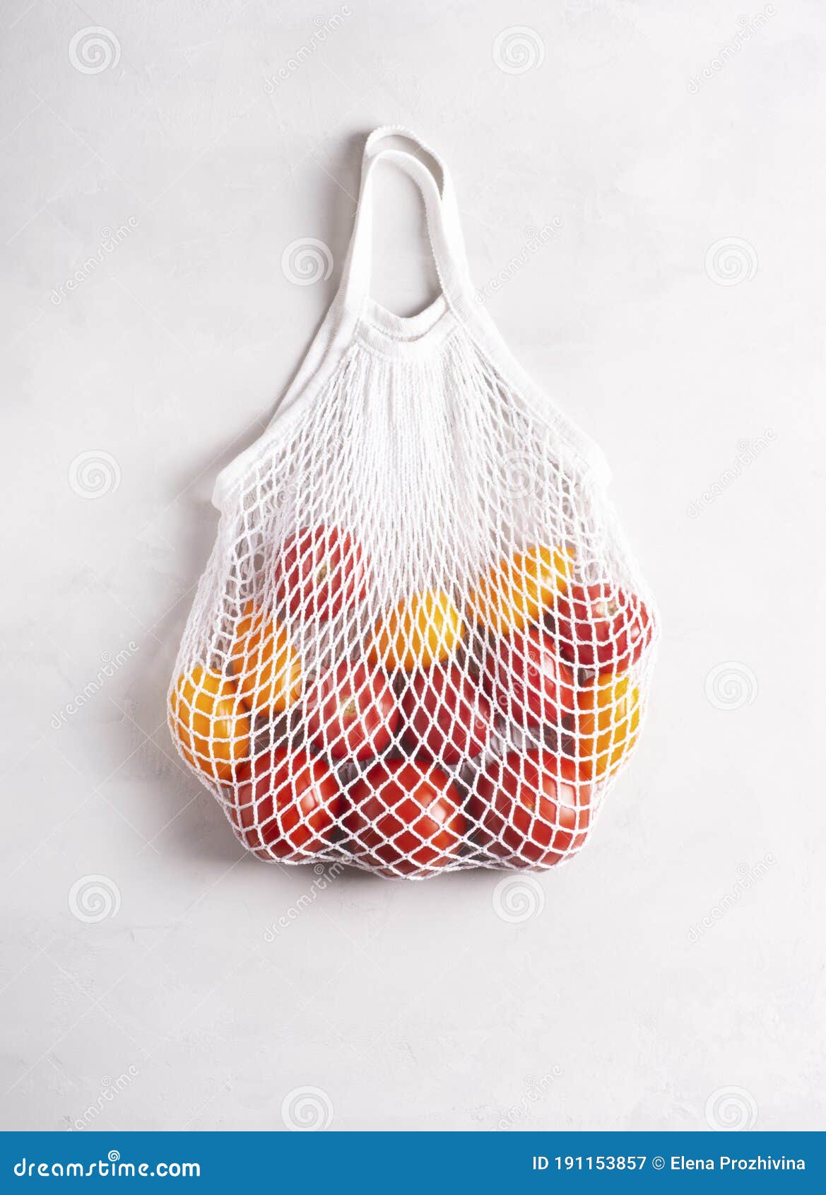 Ecofriendly Mesh Bag with Tomatoes on a Gray Surface, Flat Lay, Top