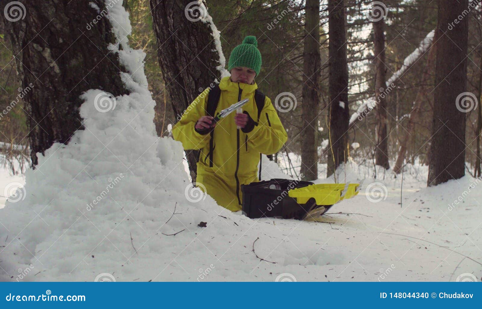 ecologist in winter forest getting sampels of the snow