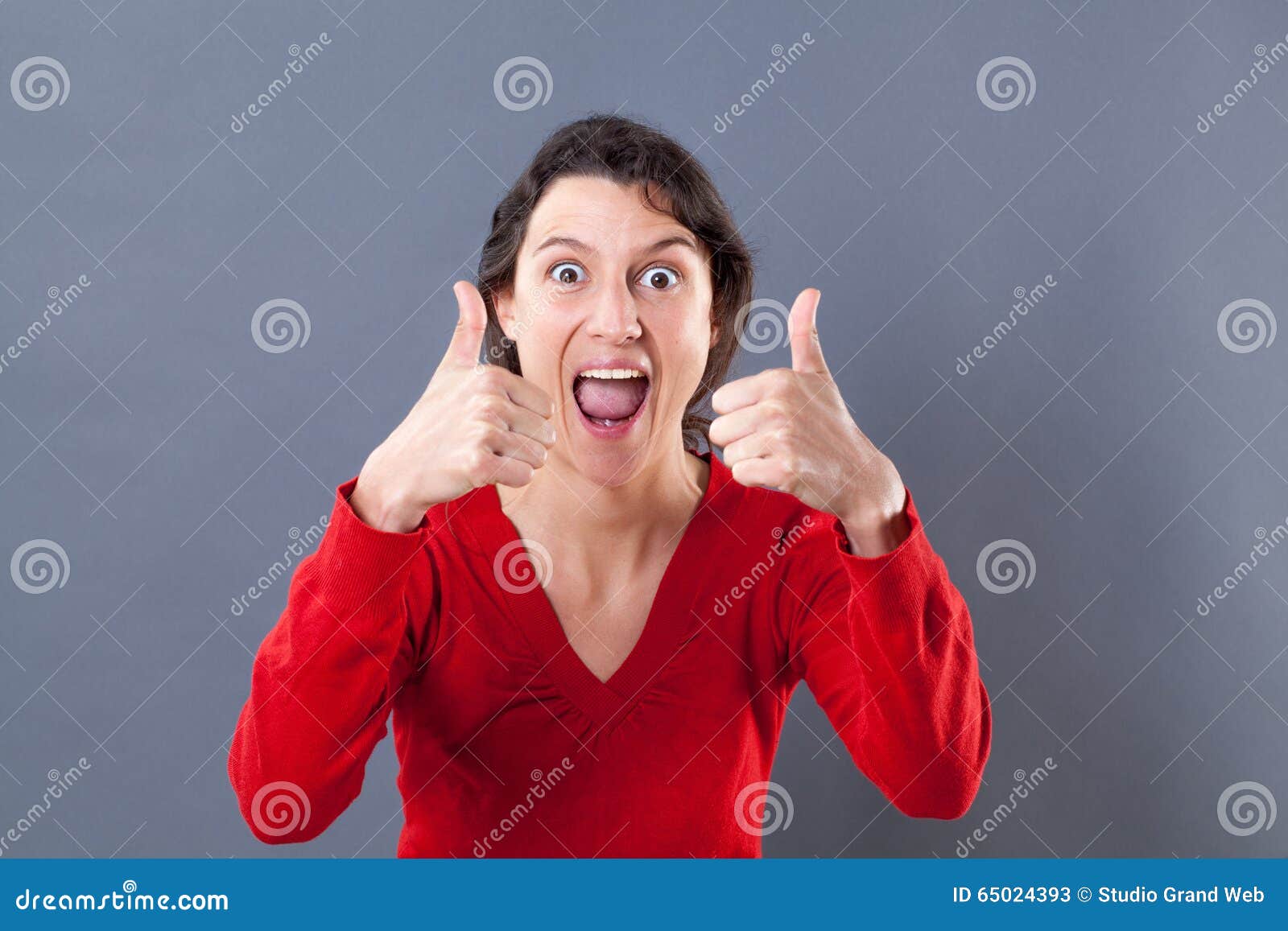 ecstatic young woman shouting with thumbs up for excitement