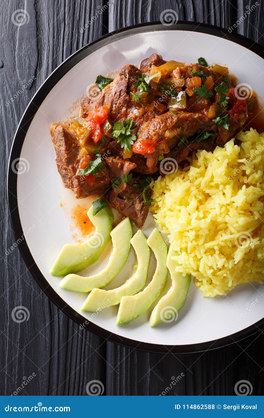 ecuadorian seco de chivo stewed goat meat with a side dish of ye