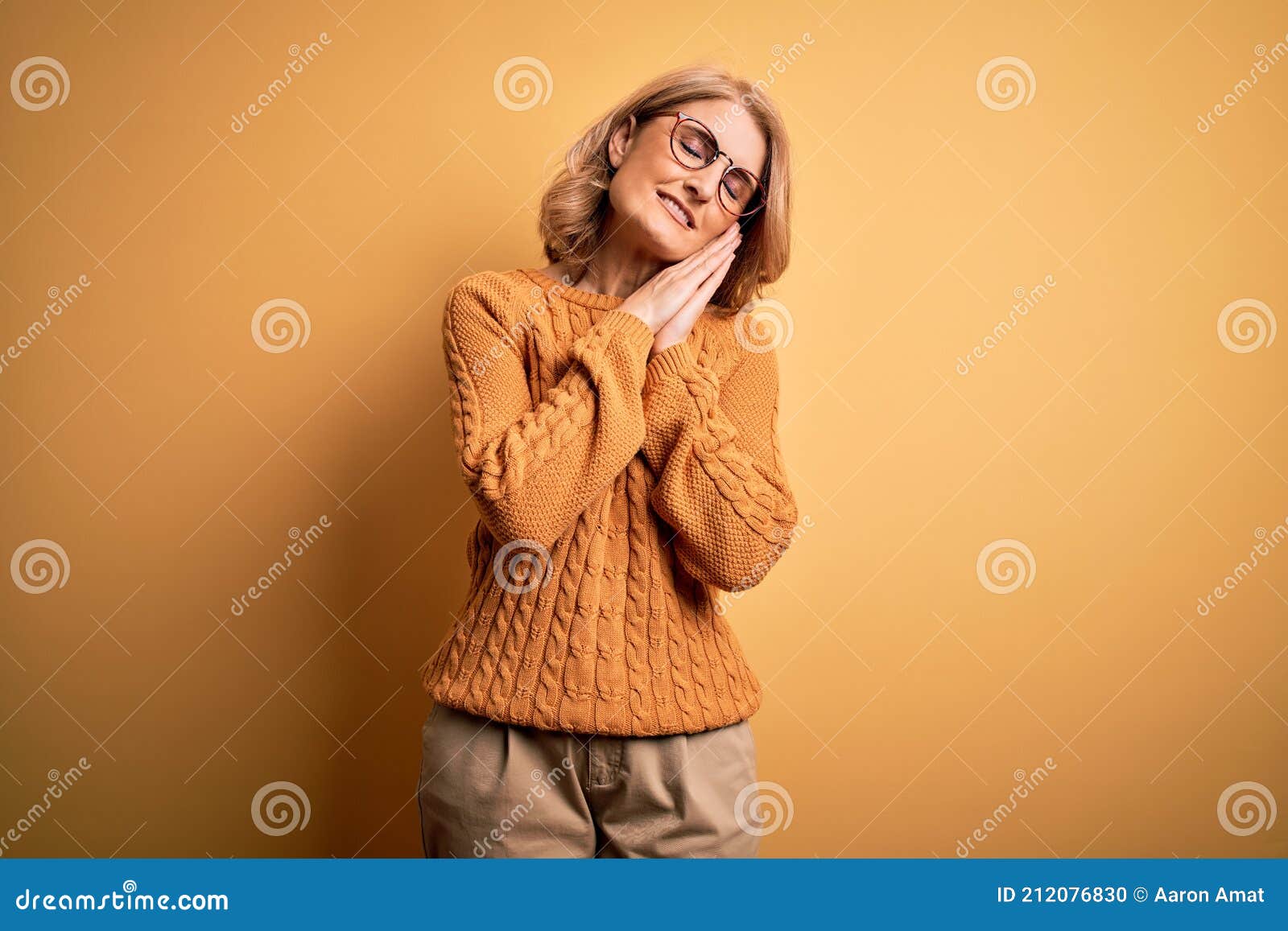 Edad Media Hermosa Mujer Rubia Con Suéter Casual Y Gafas Sobre Fondo Amarillo Cansada Soñando Y Posando Foto de - Imagen de cristales, mayor: 212076830