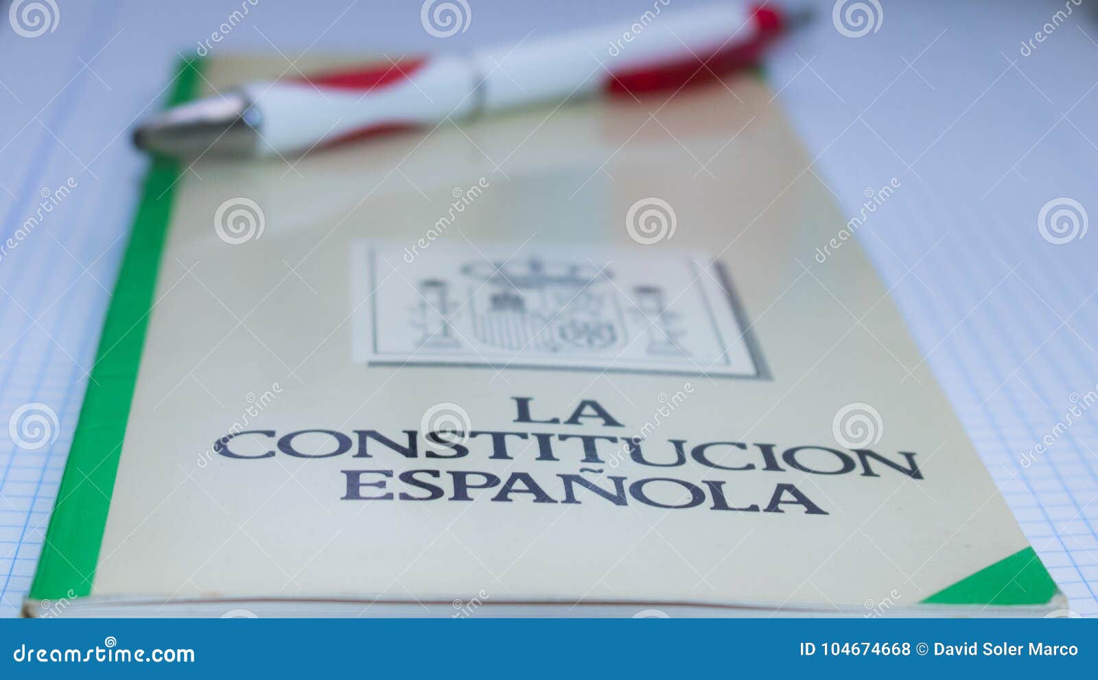 book of the spanish constitution wiht a pen and the graphical white background