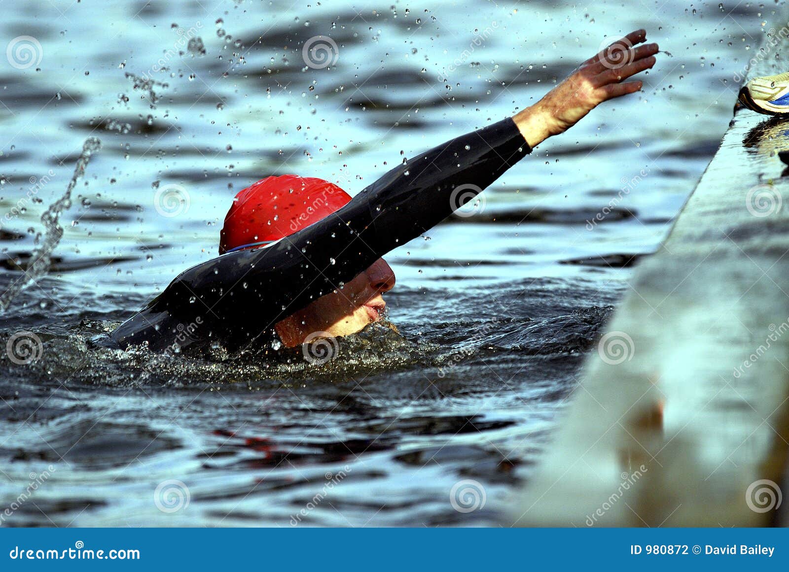 Een helpende hand. Triathlete aan het eind van een grueling rivier zwemt het bereiken van tot uitgang het water