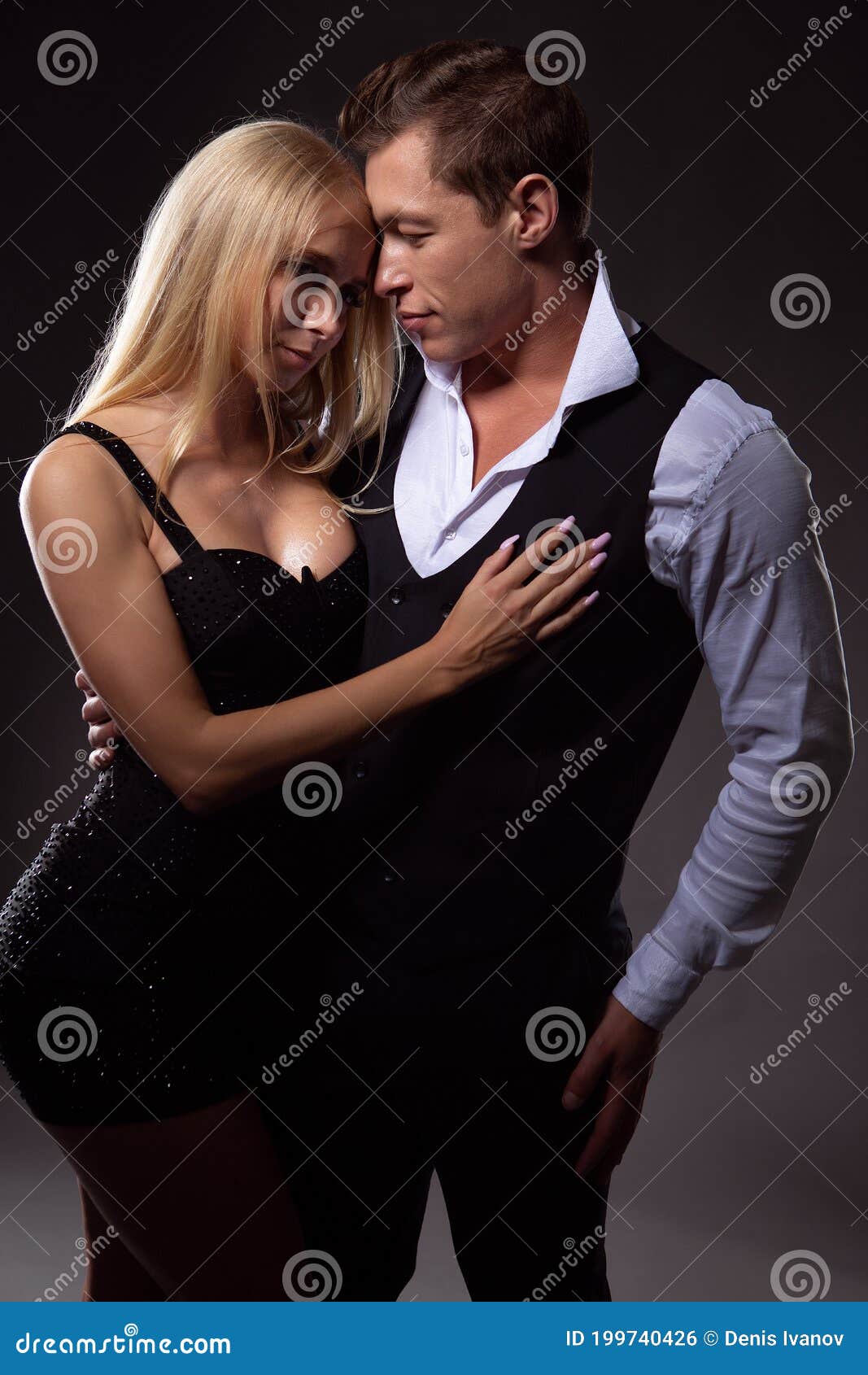 Een Jong Stel in Liefde, Een Jonge Vrouw in Een Sexy Zwarte Jurk En Een Man in Liefde Die Haar Omhelst Stock Foto foto afbeelding