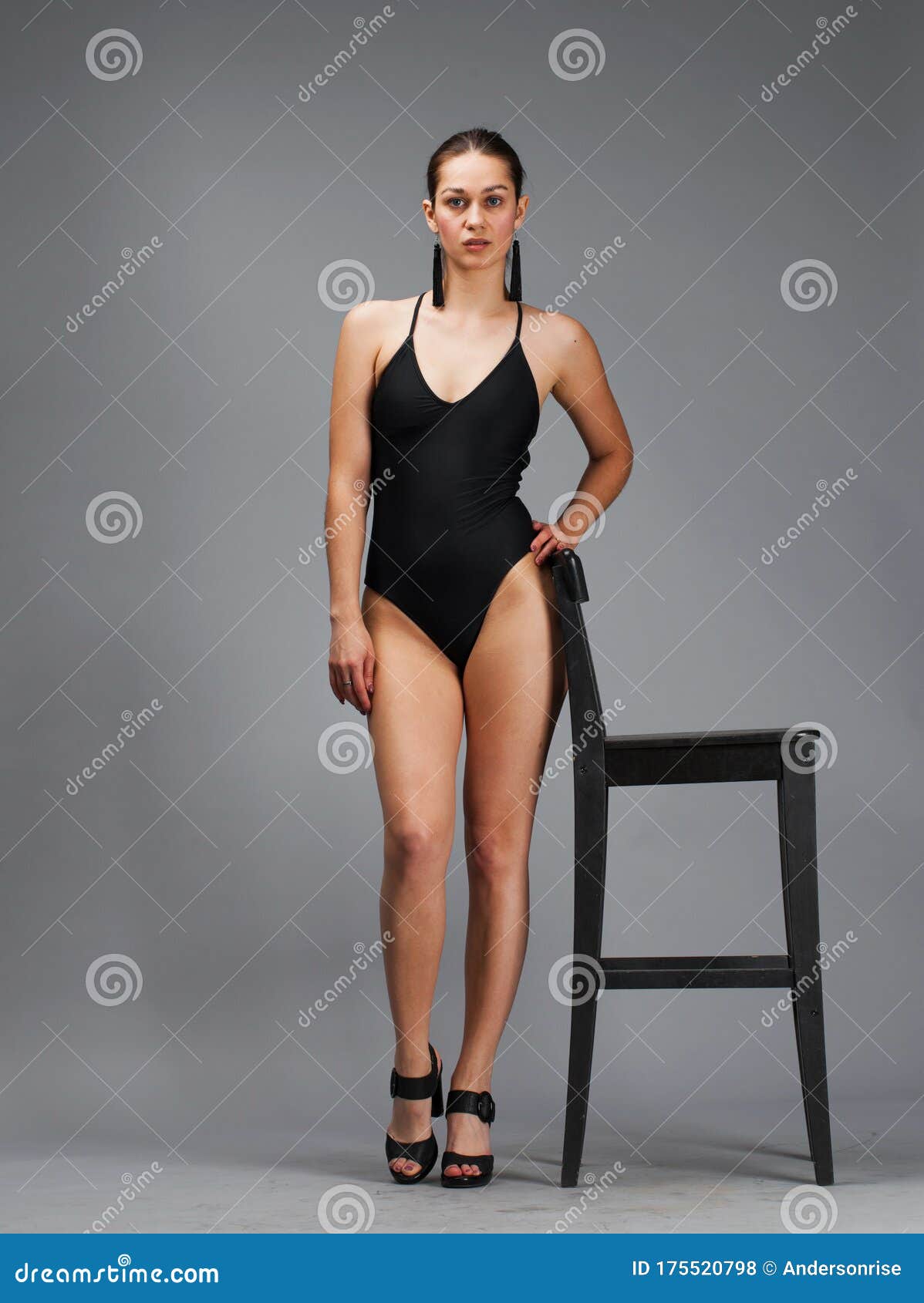 Een Jonge Mooie Brunette Vrouw in Een Zwart Stevige Zwempak Een Stoel in De Studio Zit Stock Foto - Image of elegantie, schoonheid: 175520798