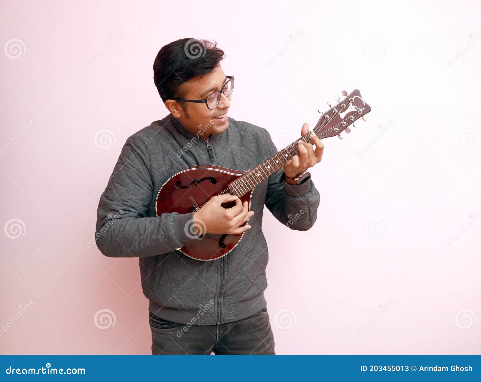 Een Stijlvolle Jonge Indiase Muzikant Met Bril in Jurk Die Mandolin in Een Sfeer Speelt. Man Die Gitaar Speelt En Stock Afbeelding - Image of opgetogen, spelen: 203455013