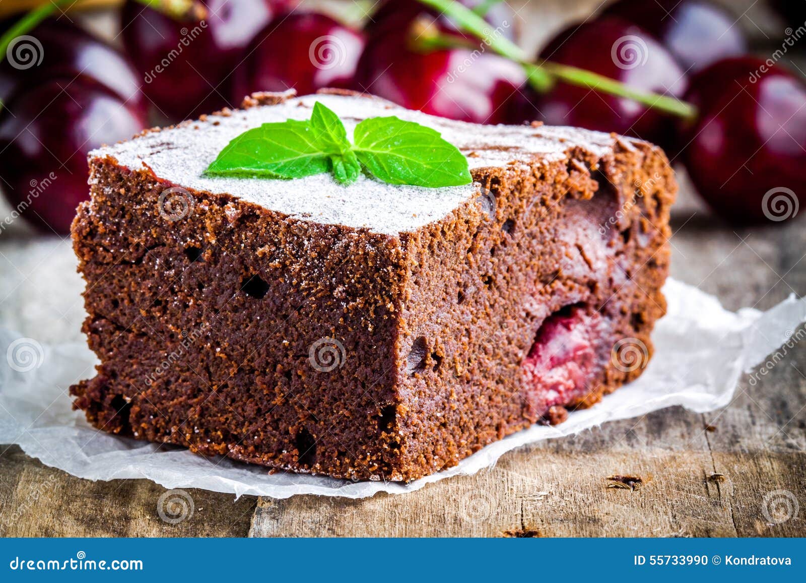 Een stuk van het eigengemaakte dessert van de chocoladebrownie met een kers op een plaatclose-up