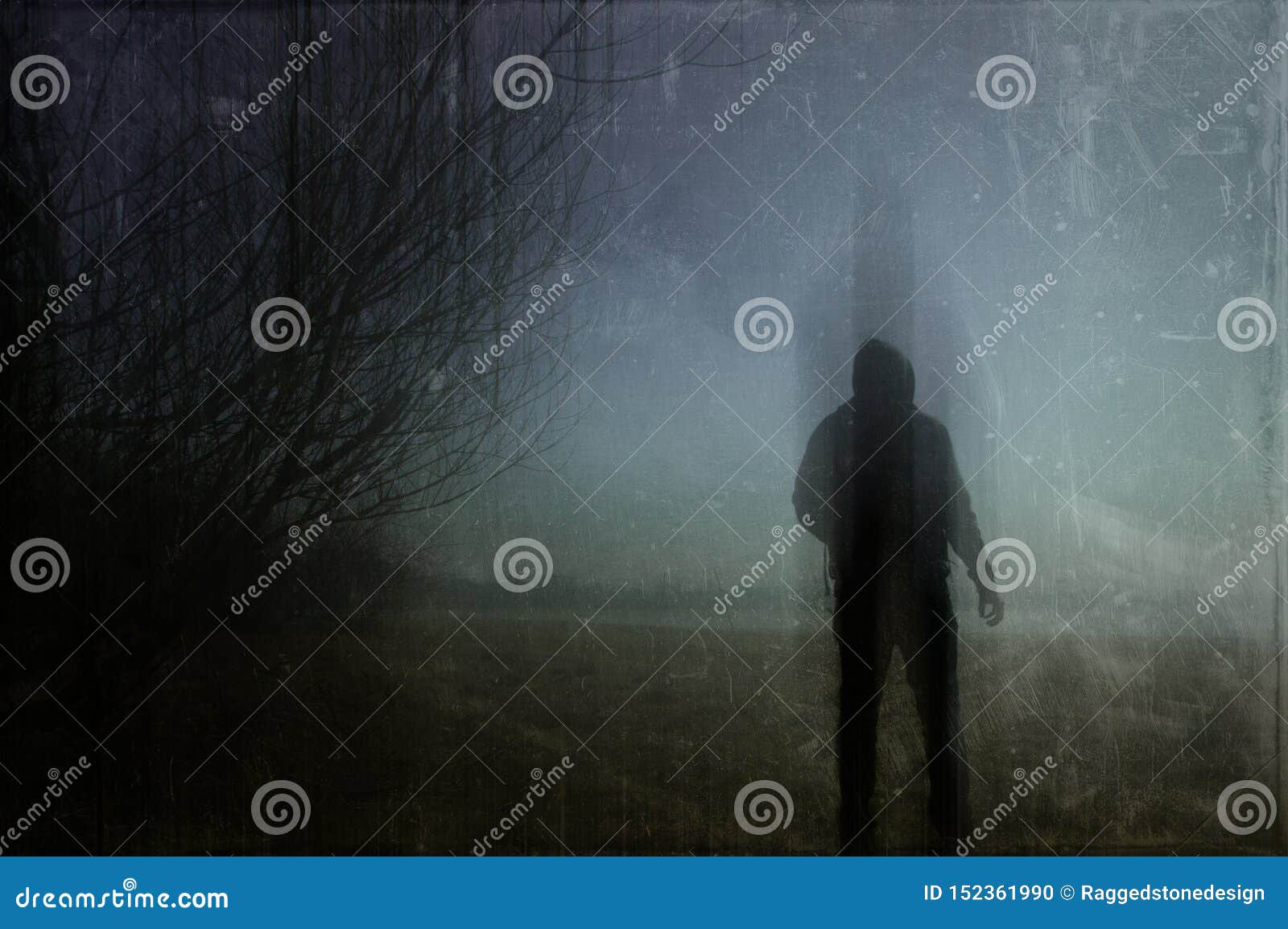 An Eerie Silhouette of a Lone Hooded Figure in a Field on a Winters ...