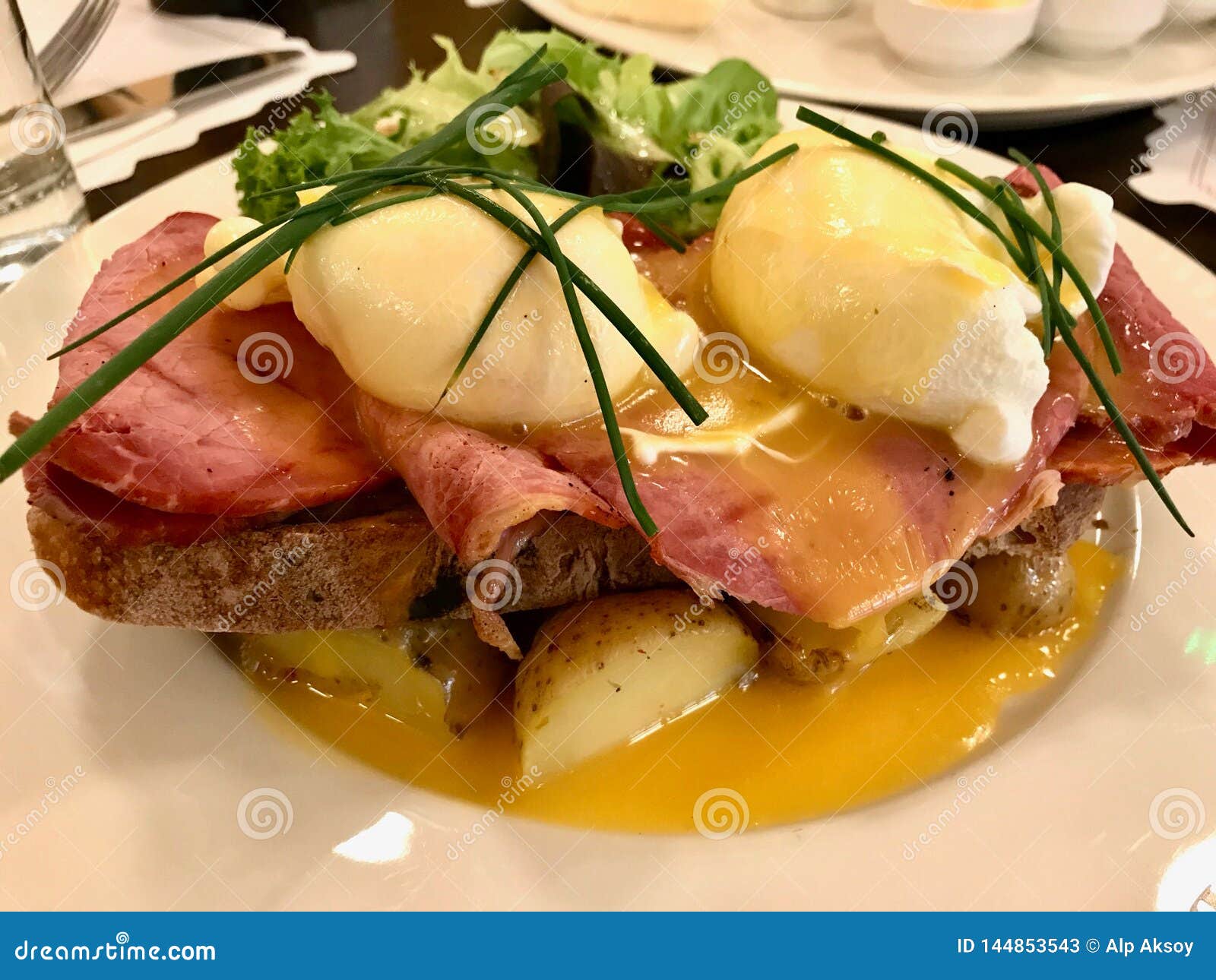Egg Benedict with Roast Beef, Potatoes and Chives Served at Restaurant