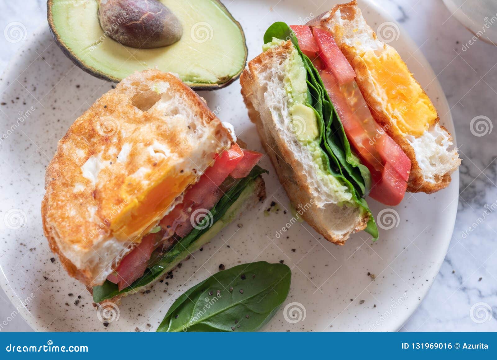 Egg in a Hole Sandwich with Avocado, Spinach and Tomato Stock Photo