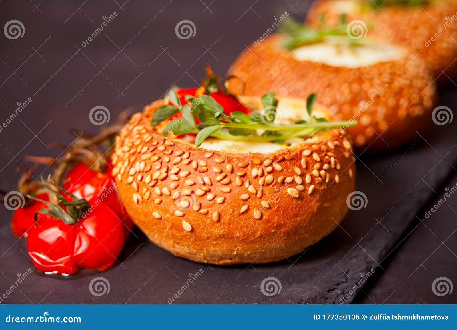 Egg Served in Bread Bowl. Breakfast Baked Eggs in Bread Bowls with the Fresh Herbs Stock Photo