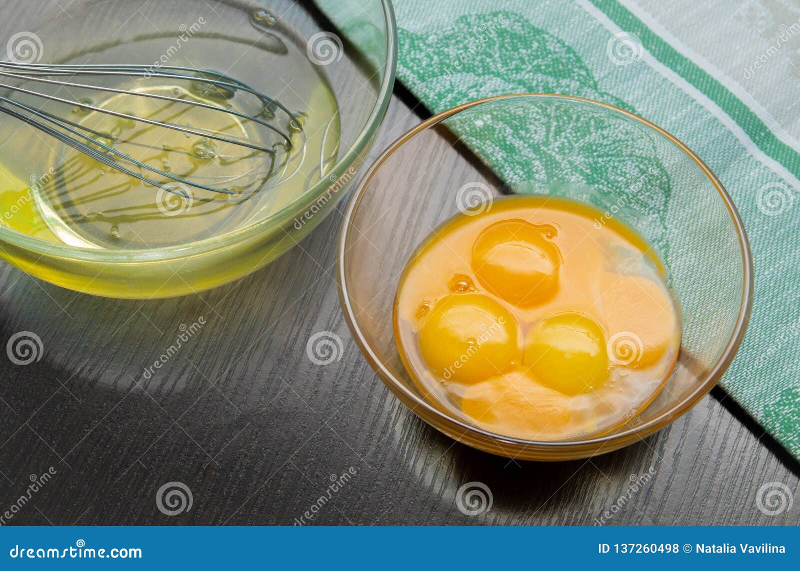 Egg Whites and Yolks in Transparent Glass Cups with a Whisk Next Stock