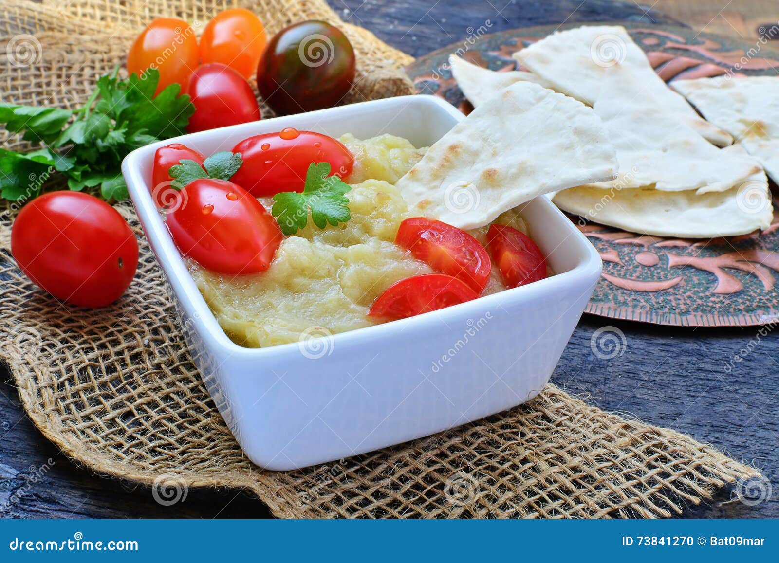 Eggplant Dip with Pita Bread and Grape Tomatoes on Rustic Table Setting
